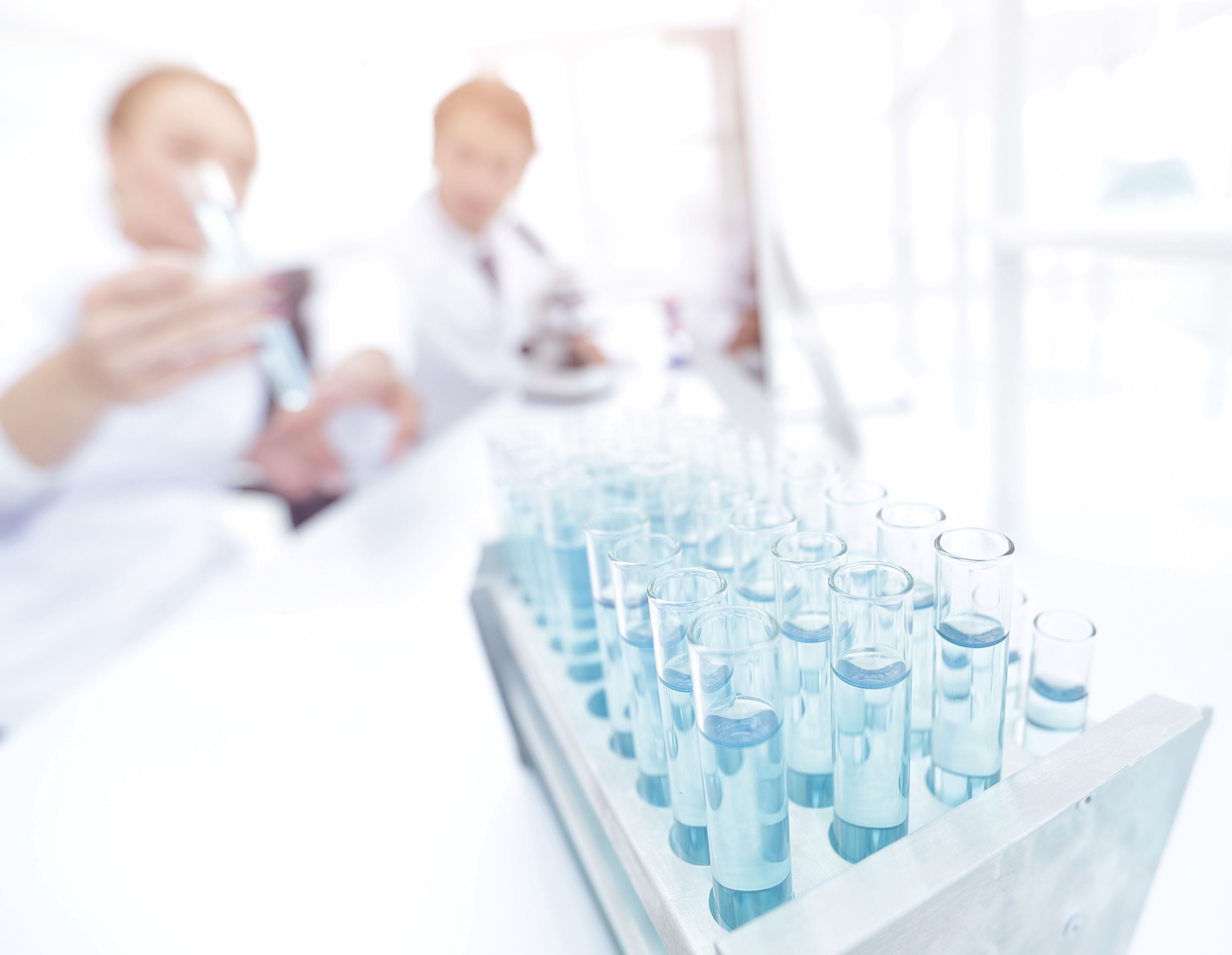 Folk på laboratorie holder reagensglass