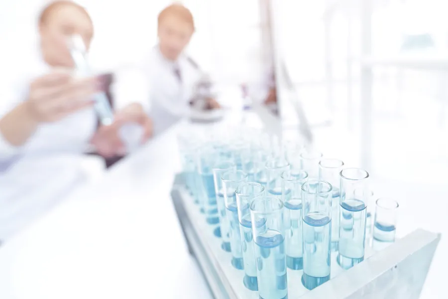 Folk på laboratorie holder reagensglass