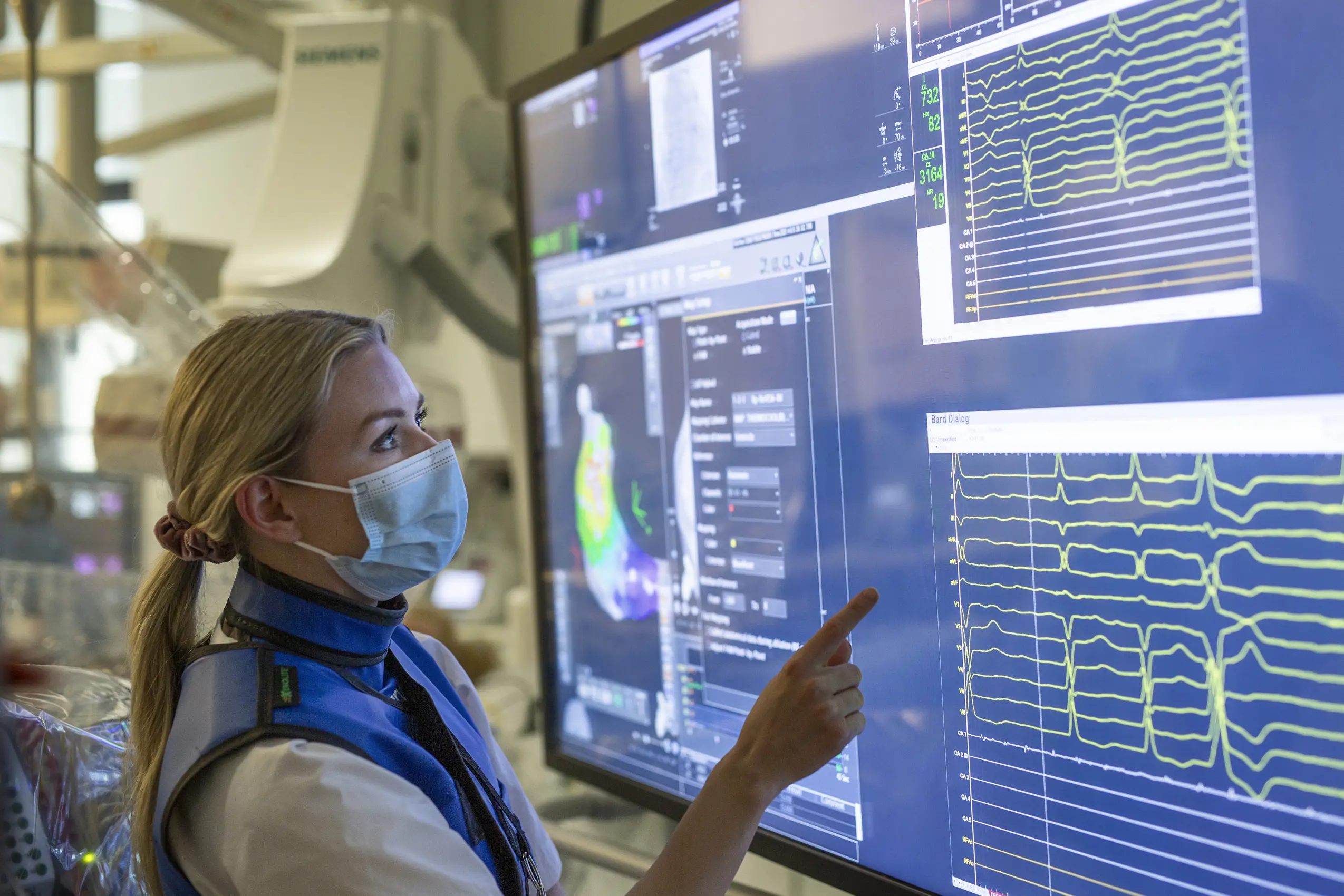 Lege som ser på en stor skjerm med masse data