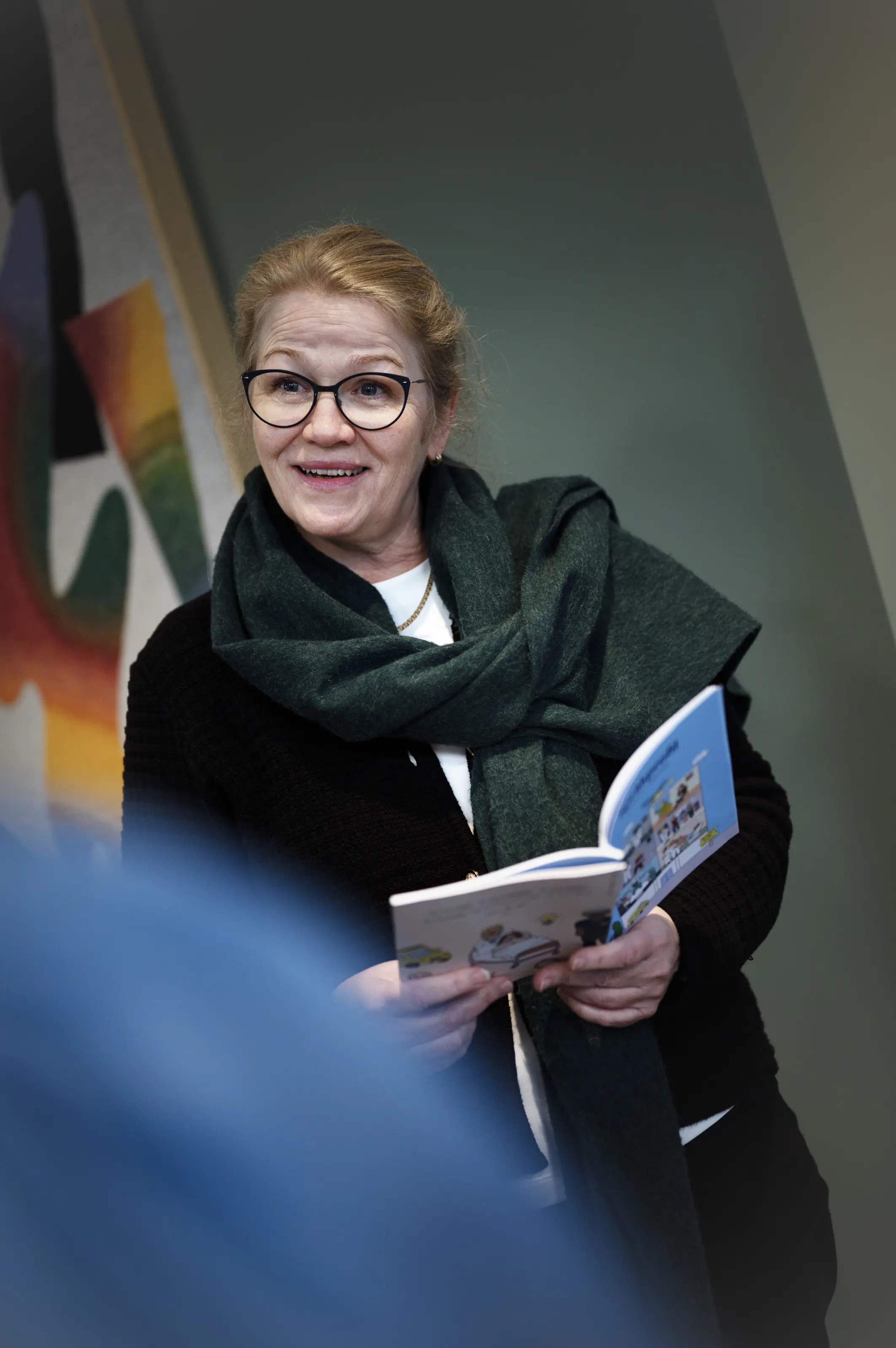 Dame står med ei bok