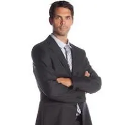 En mann i dress med armene i kors