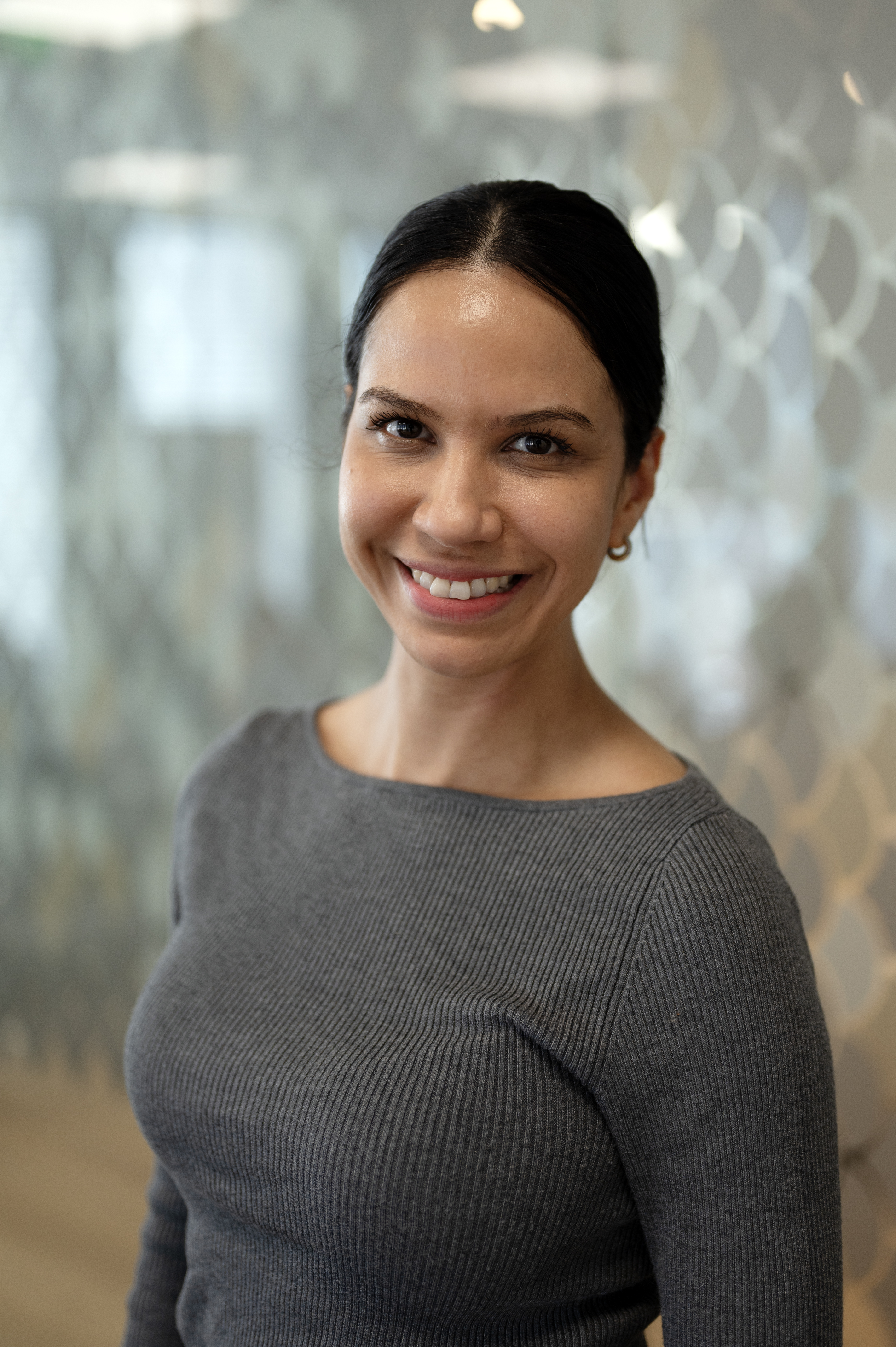 Kvinne ser i kamera og smiler