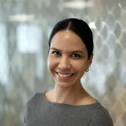 Kvinne ser i kamera og smiler