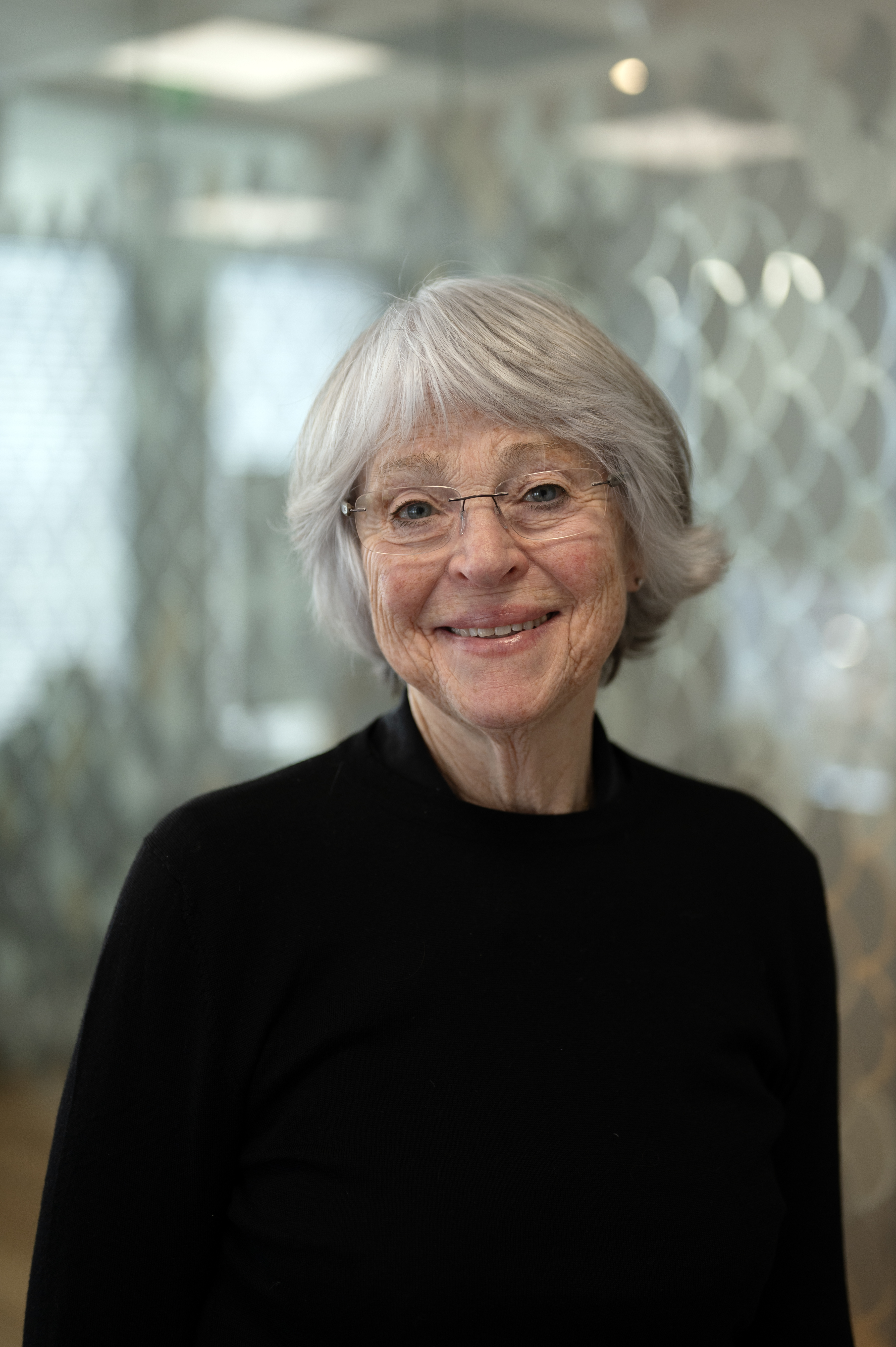 Kvinne ser i kamera og smiler