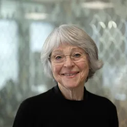 Kvinne ser i kamera og smiler