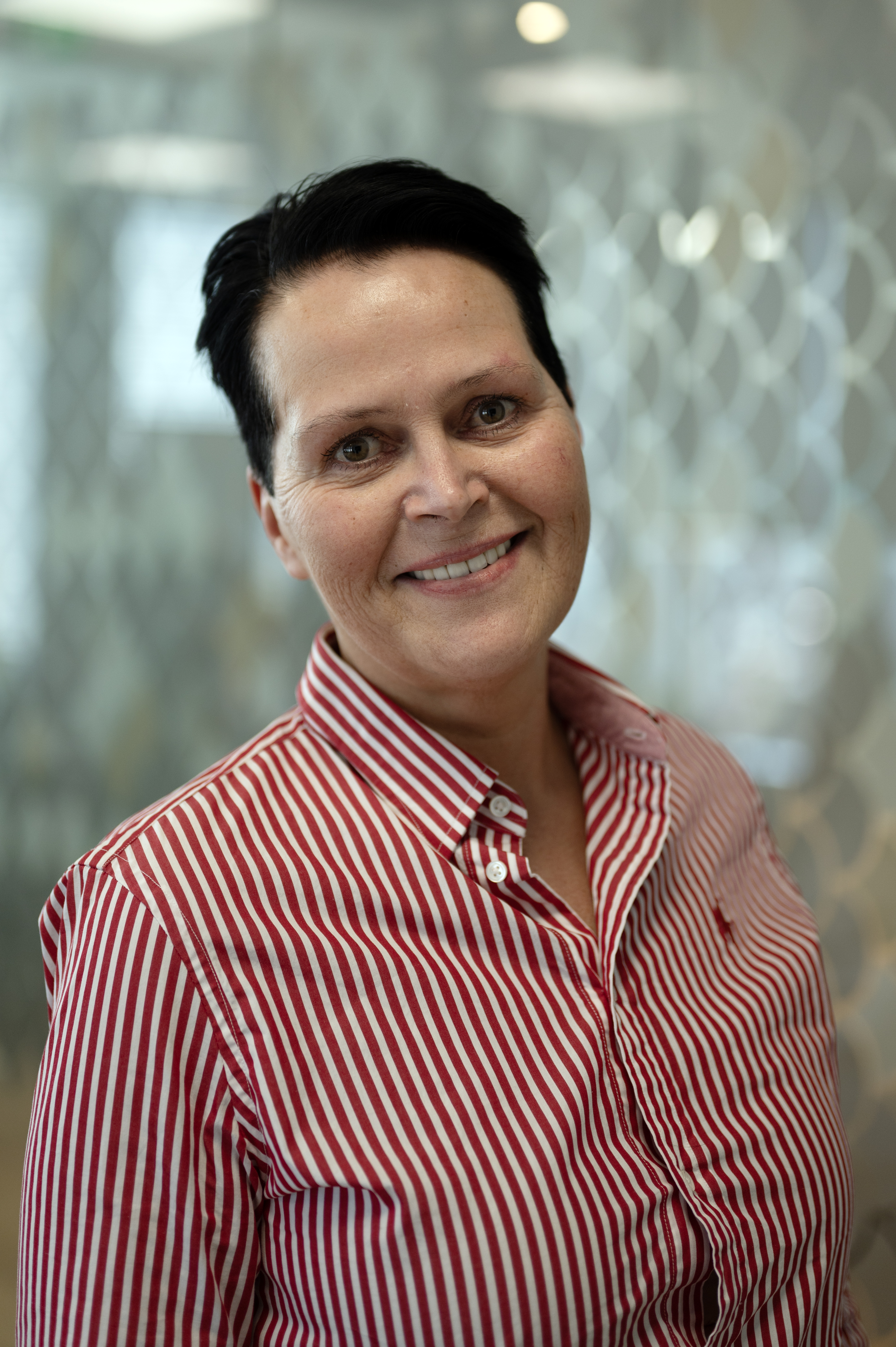 Kvinne ser i kamera og smiler