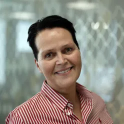 Kvinne ser i kamera og smiler