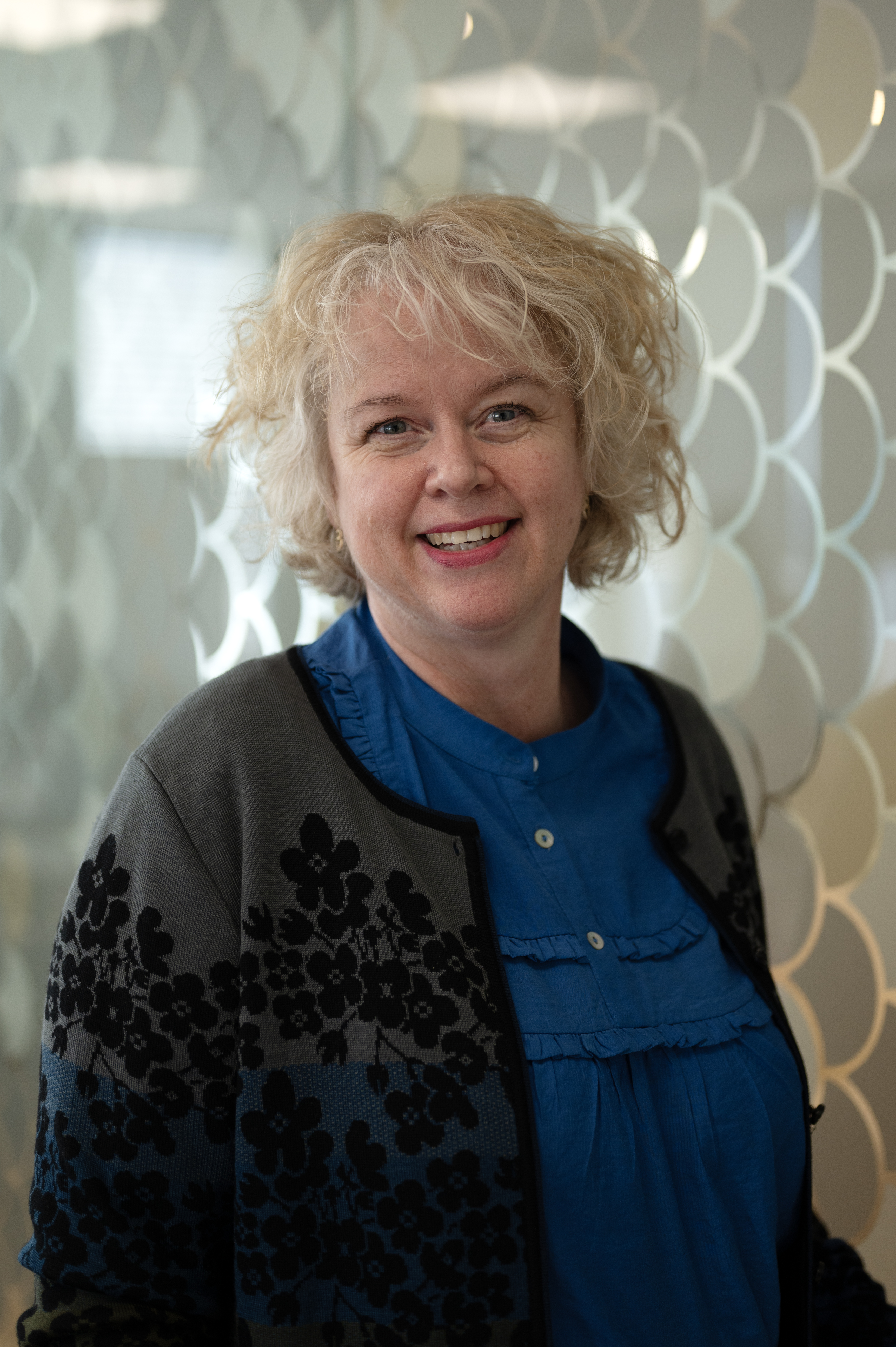 Kvinne ser i kamera og smiler