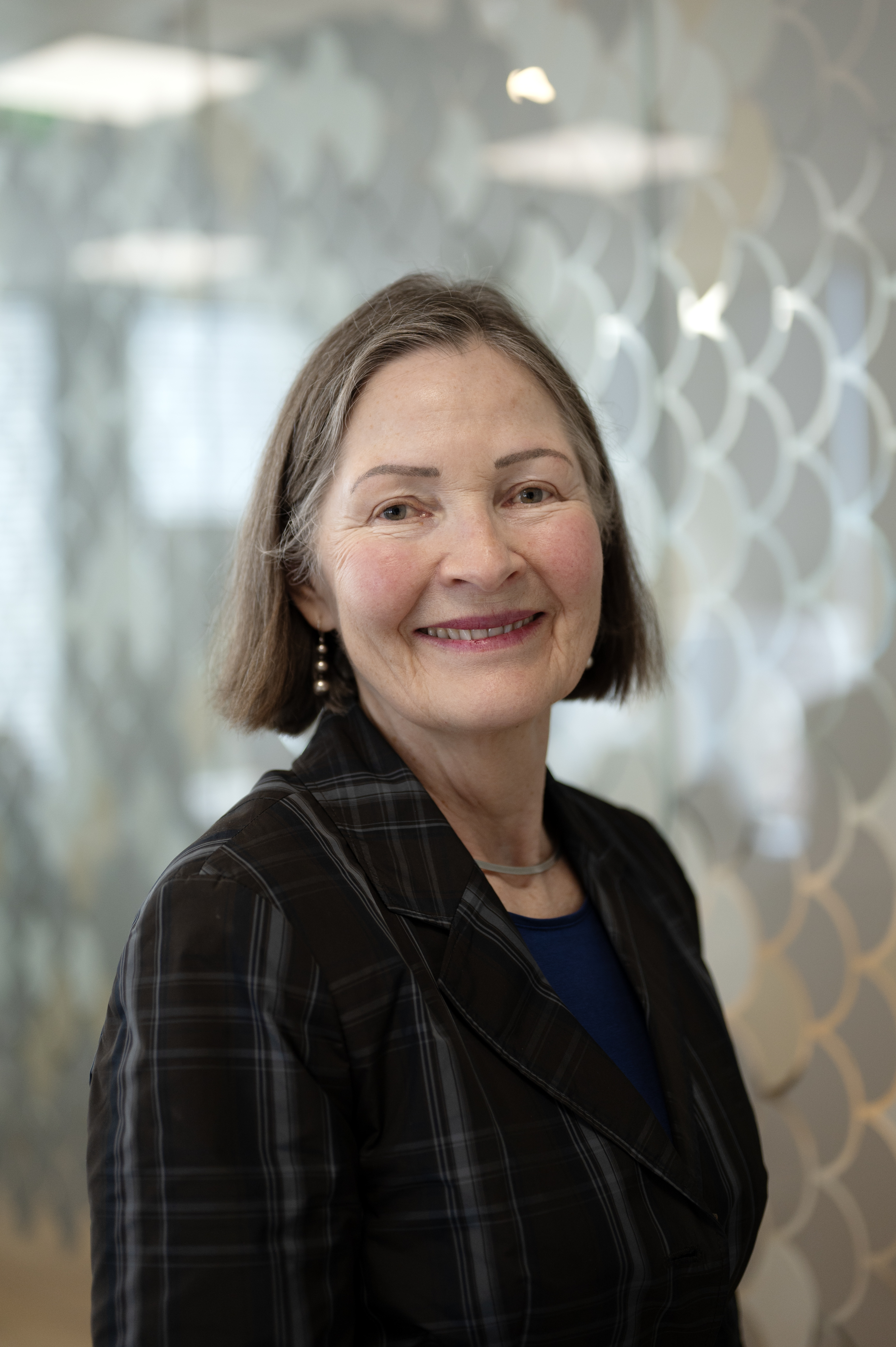 Kvinne ser i kamera og smiler