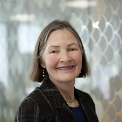 Kvinne ser i kamera og smiler