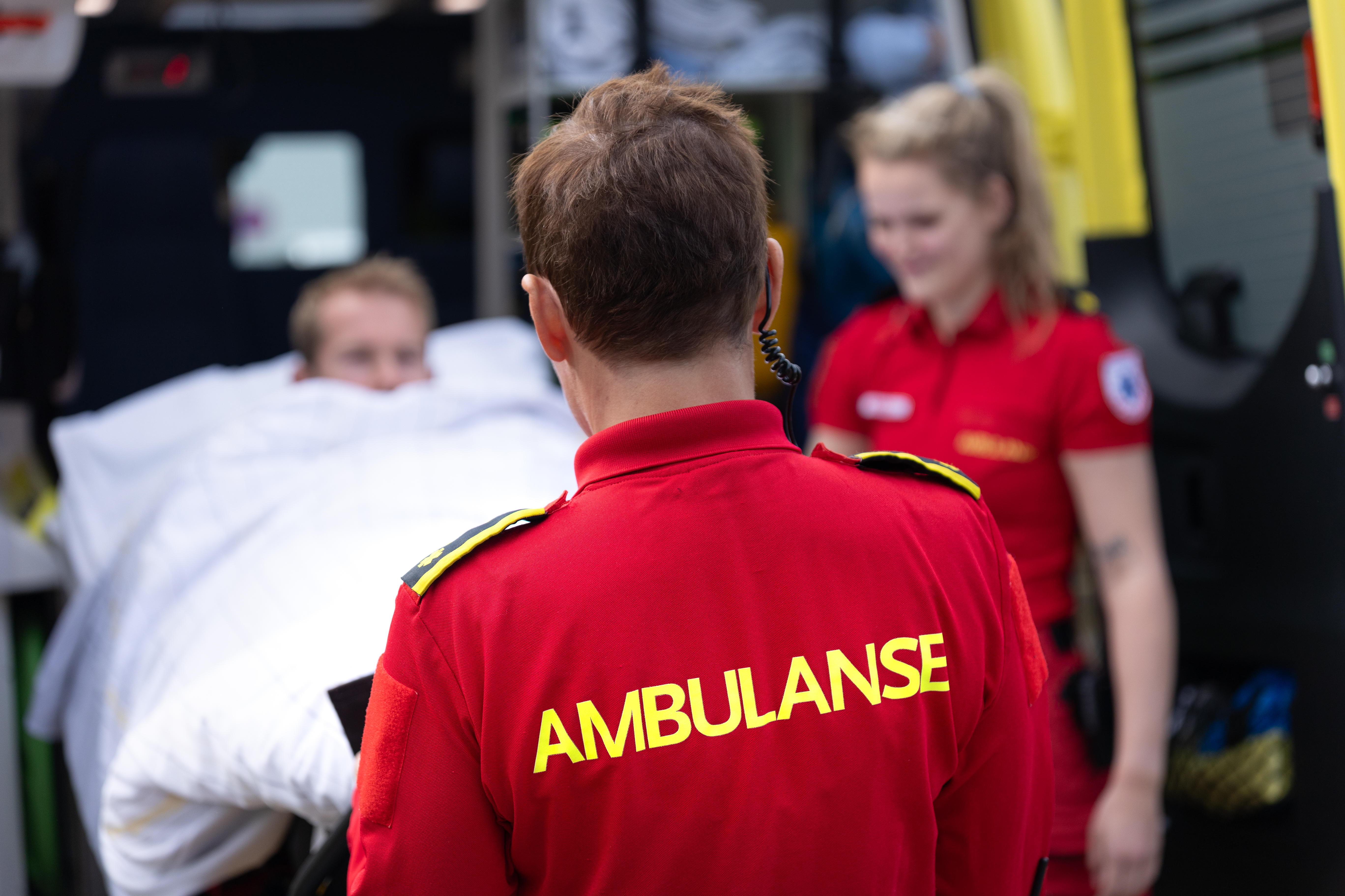To ambulansemedarbeidere og en pasient på båre