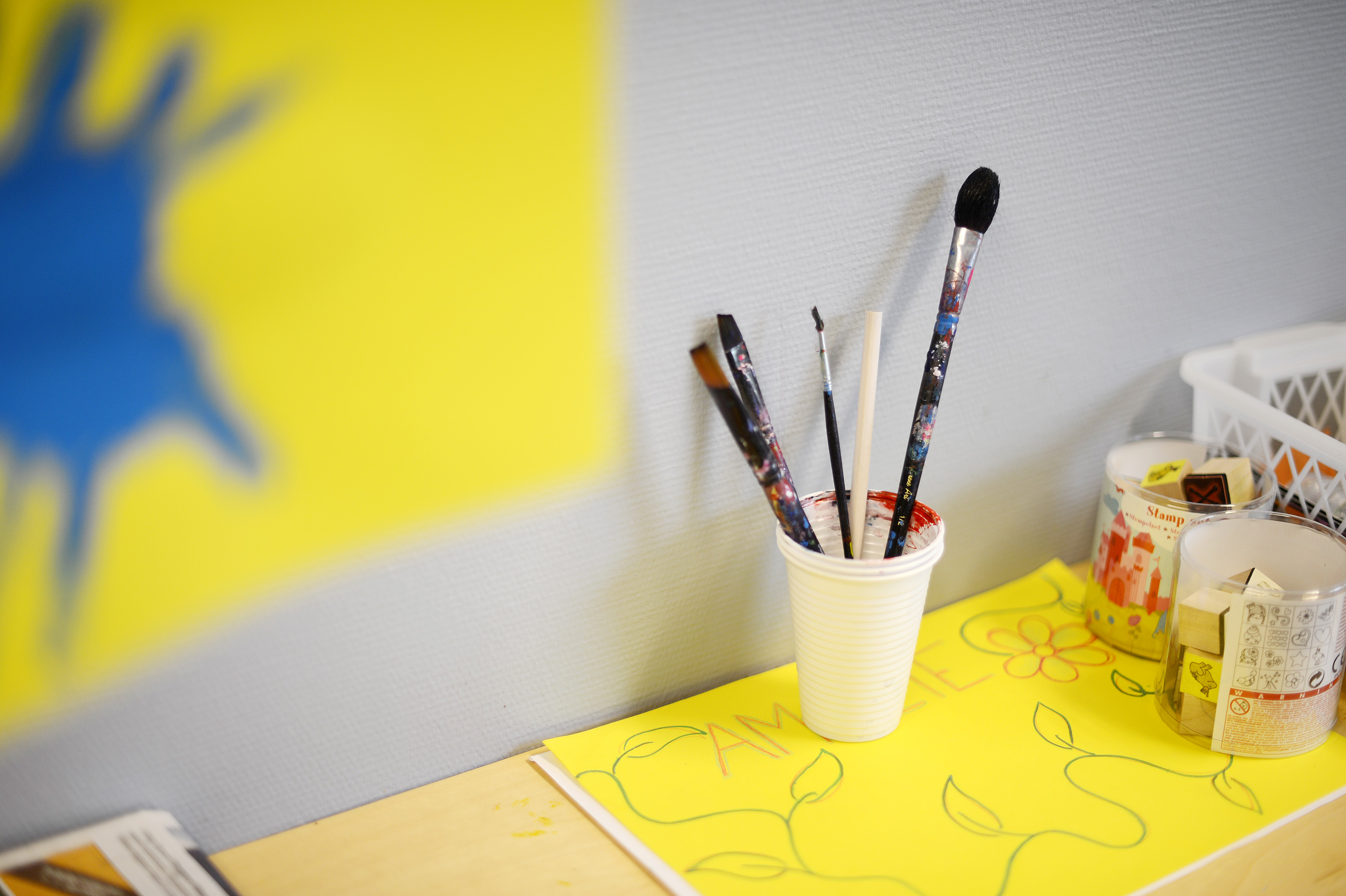 Malerpensler i glass, som står på et bord. Foto.