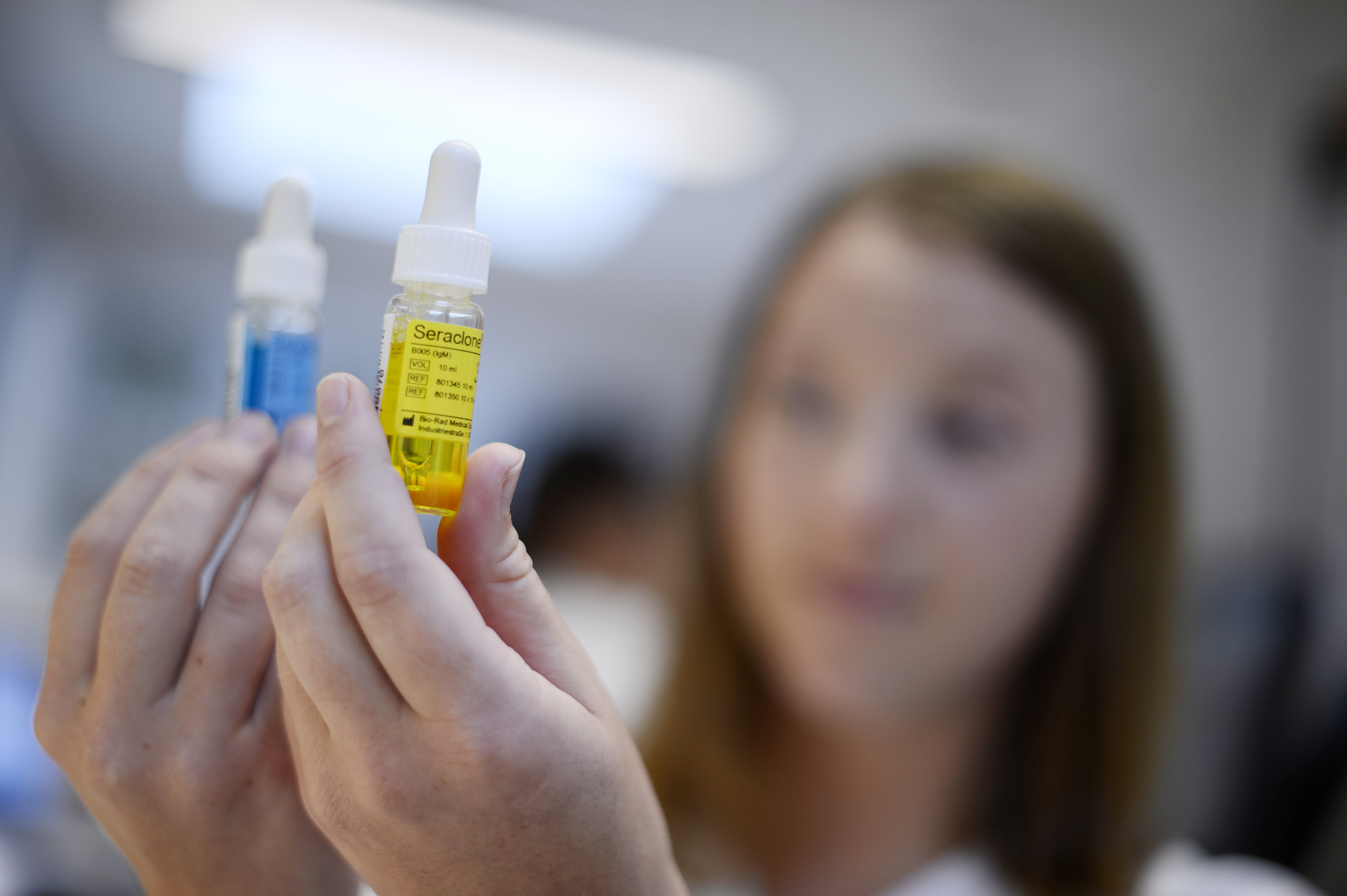 Dame som holder to medisinflasker. Foto.