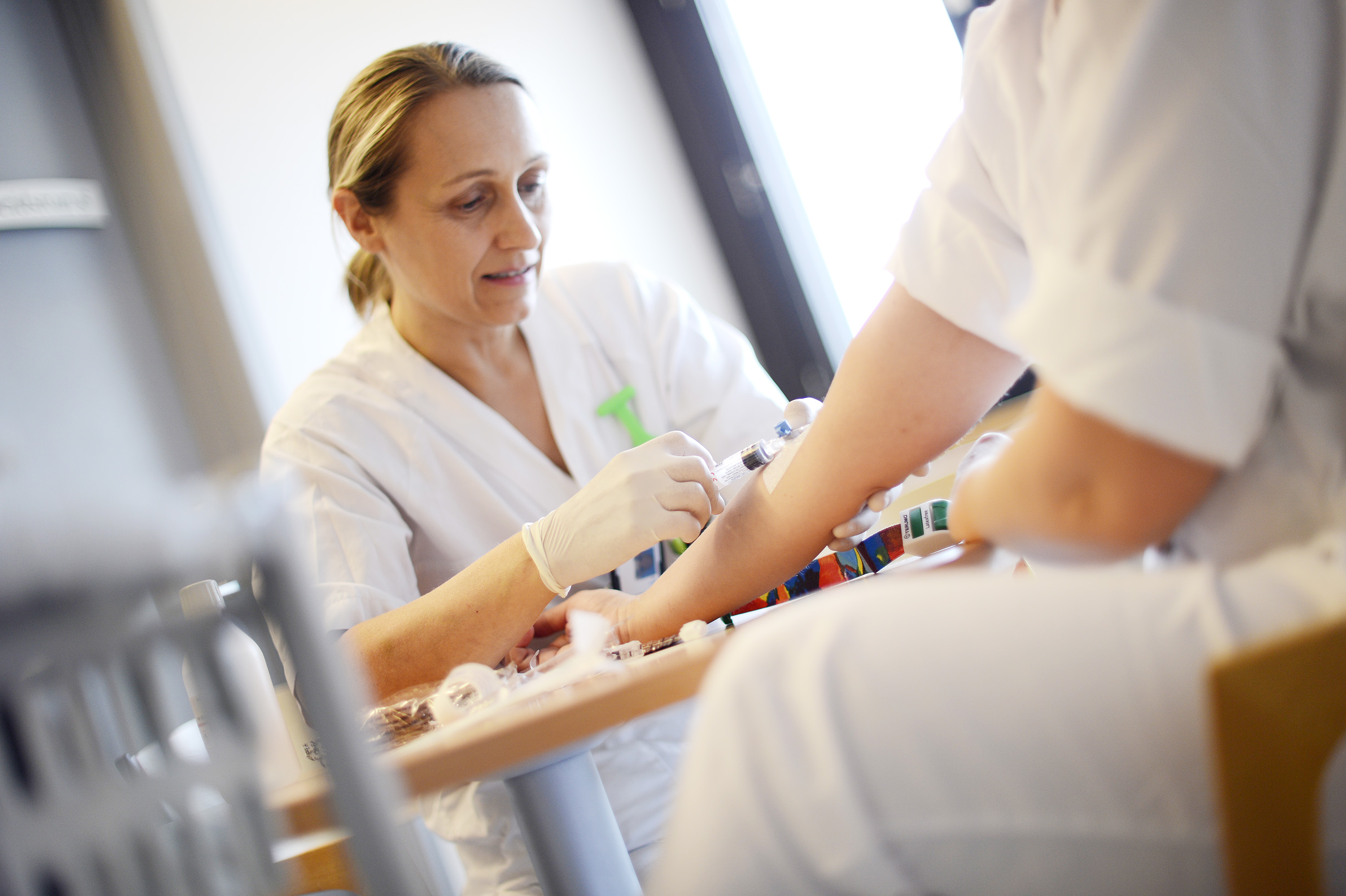 Sjukepleiar som tek blodprøve av pasient. Foto.