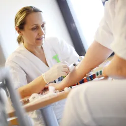 Sjukepleiar som tek blodprøve av pasient. Foto.