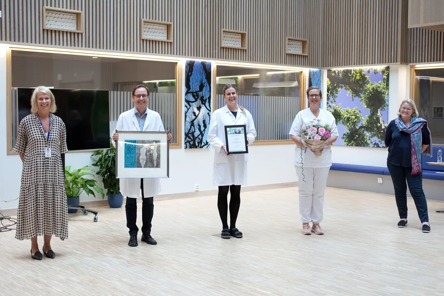 3 prisvinnere og 2 adm. dir med blomster og diplom. Foto.