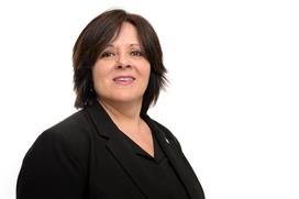 Kvinne i dress smiler. Foto.