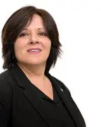 Kvinne i dress smiler. Foto.