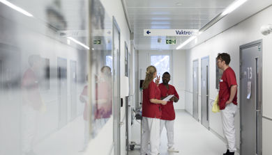 Sykehuspersonale står og snakker i korridor. Foto.