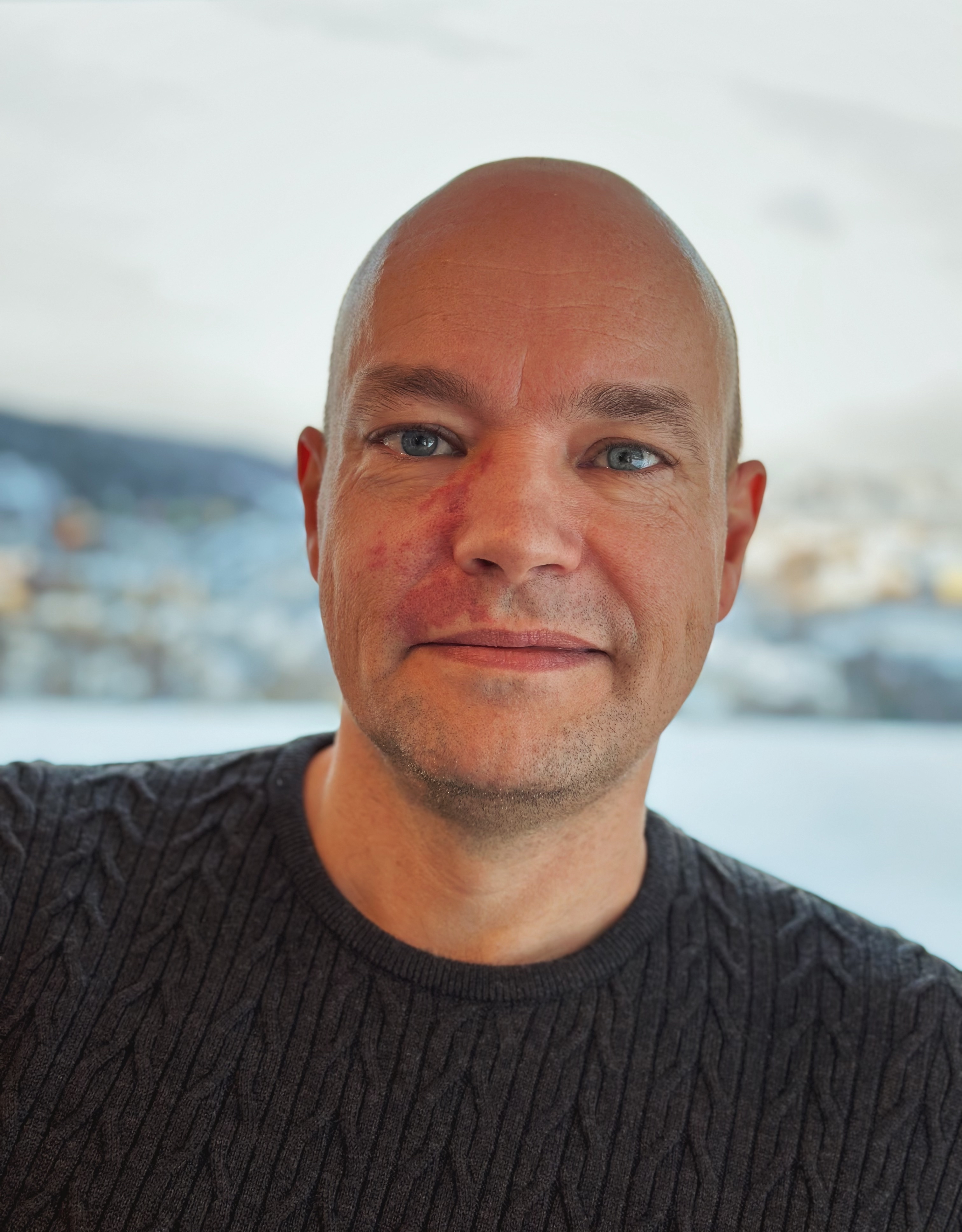 En mann som smiler til kameraet