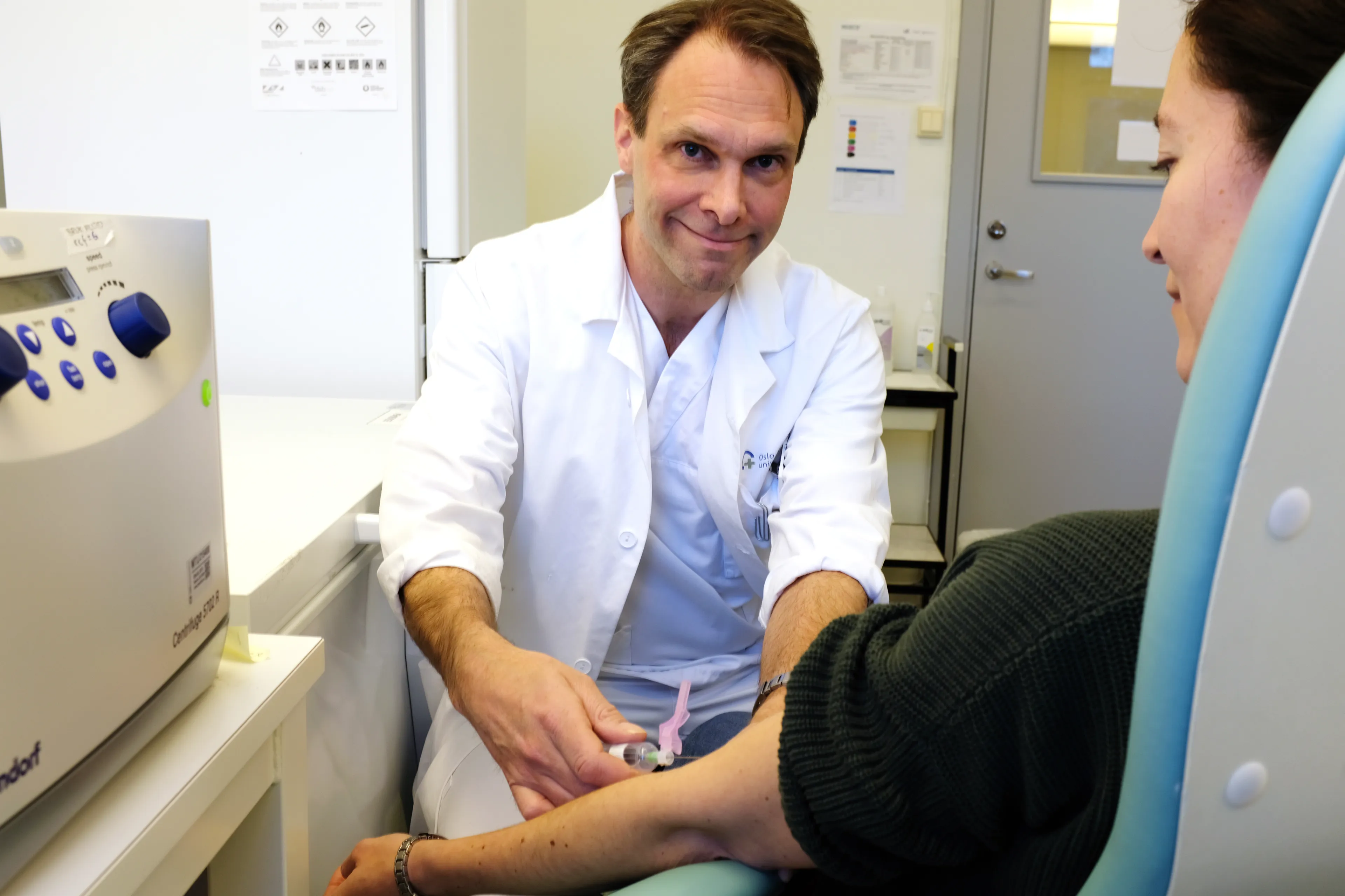 Lege tar blodprøve av pasient