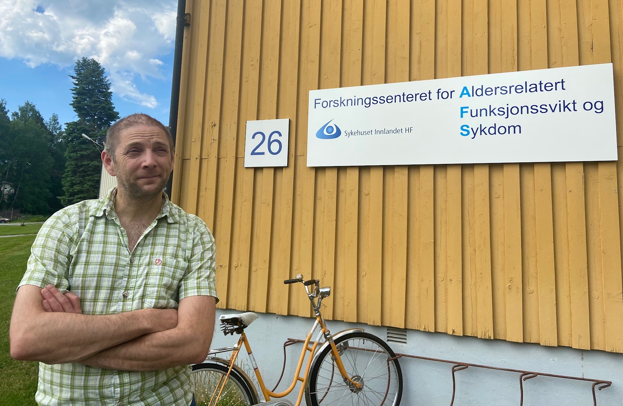 En mann som står ved siden av en sykkel