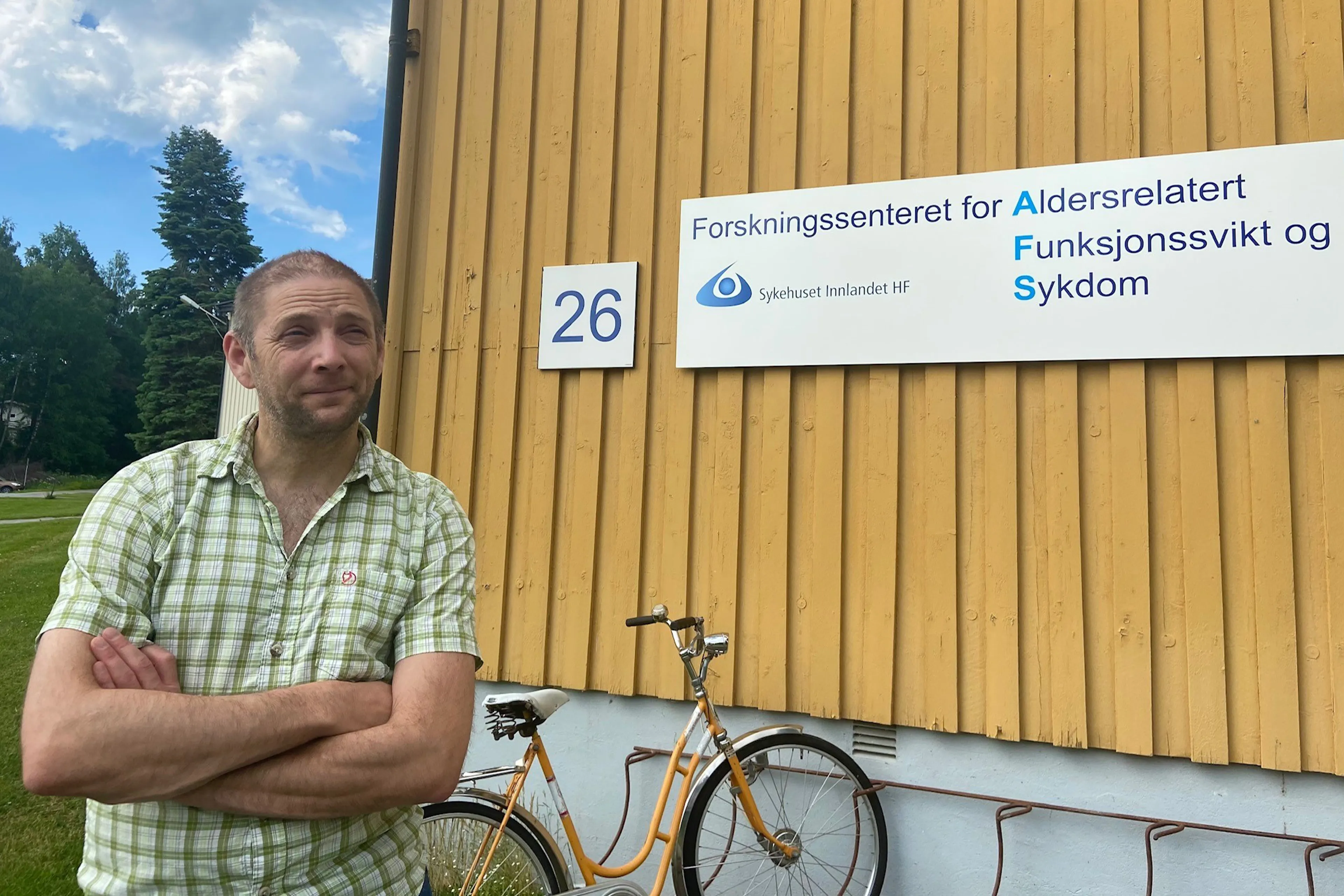 En mann som står ved siden av en sykkel