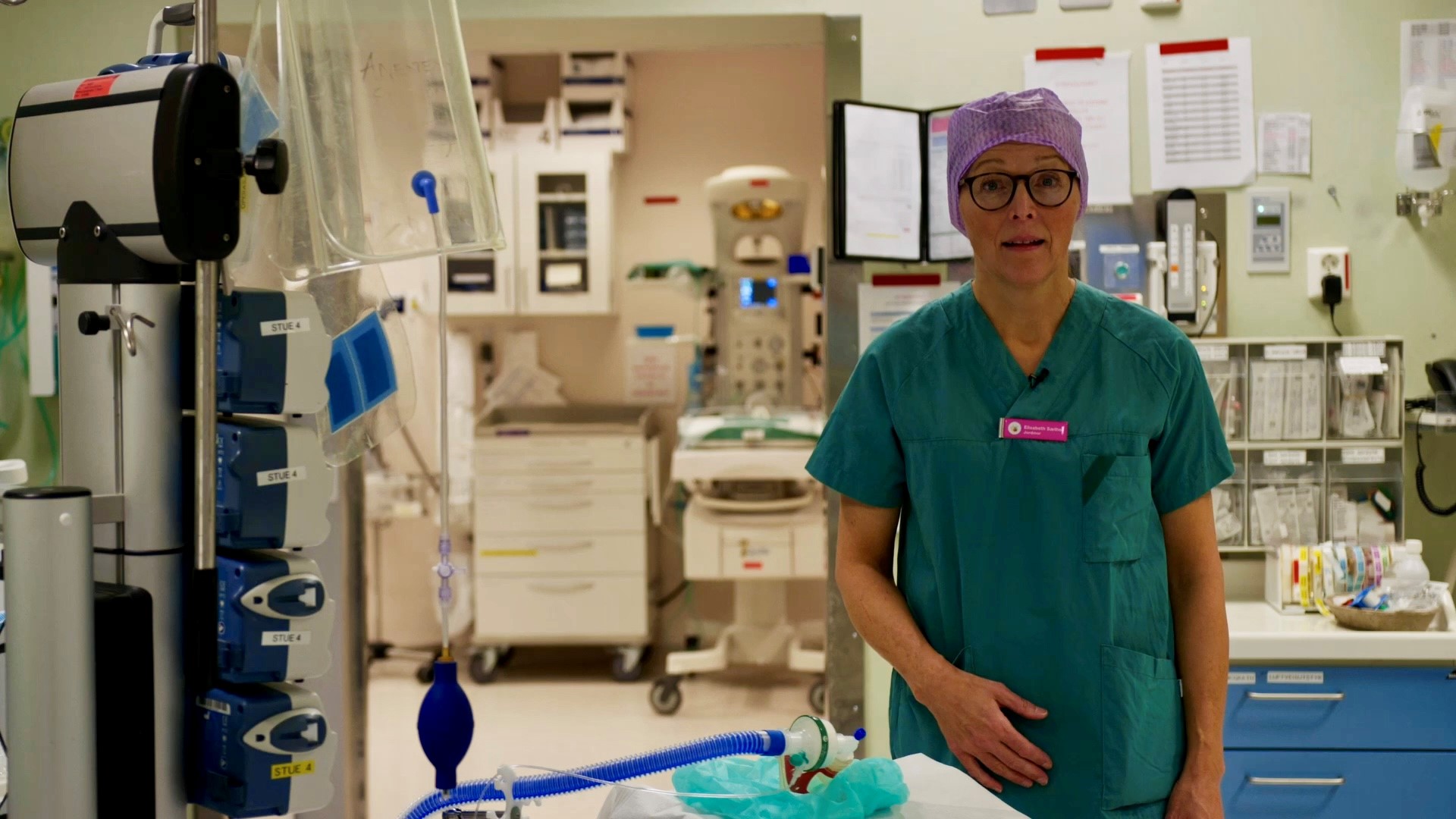 En kvinne i grønne klær på et sykehusrom