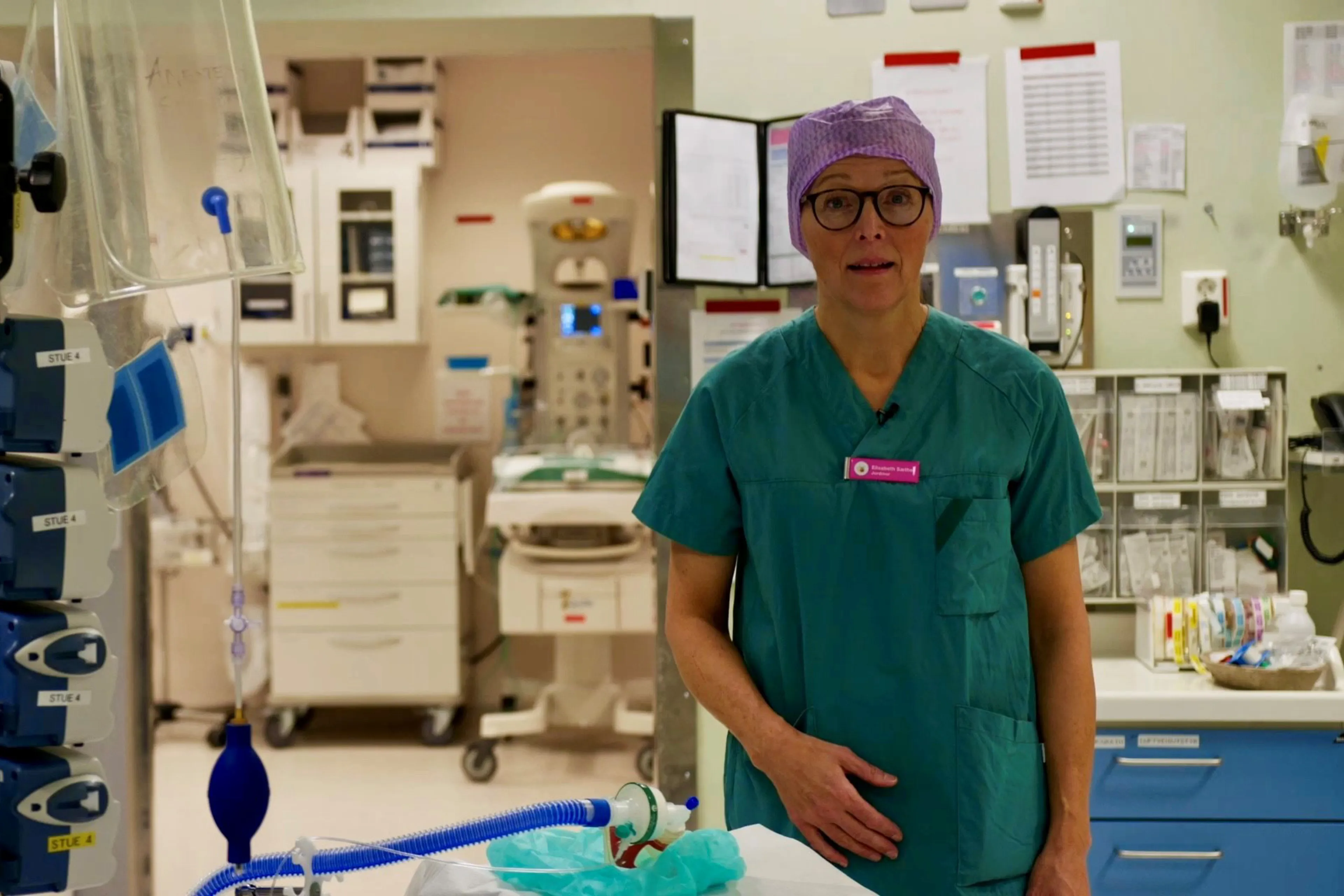 En kvinne i grønne klær på et sykehusrom