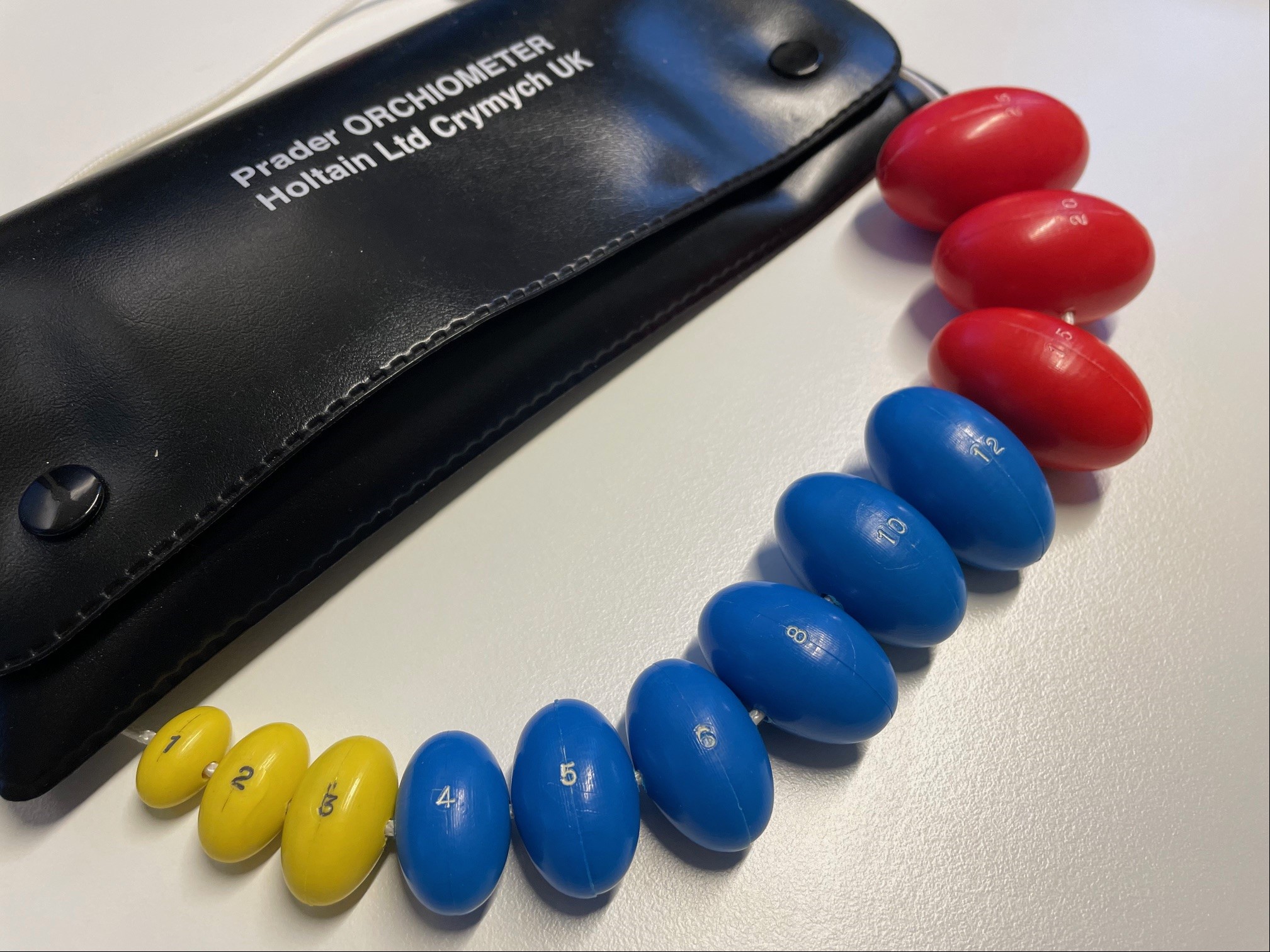 En svart "kulerad" som leger bruker for å måle størrelsen på testiklene hos pasienten.