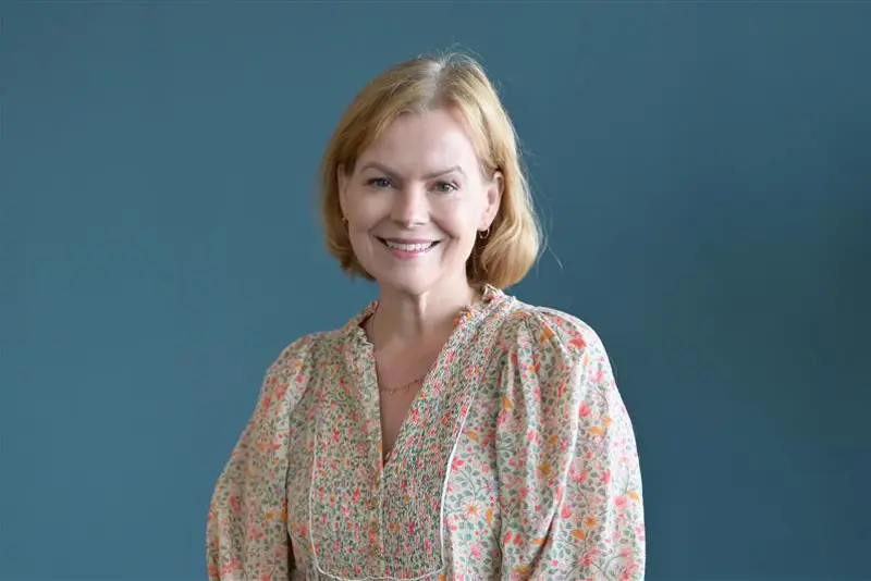 En kvinne som smiler til kameraet