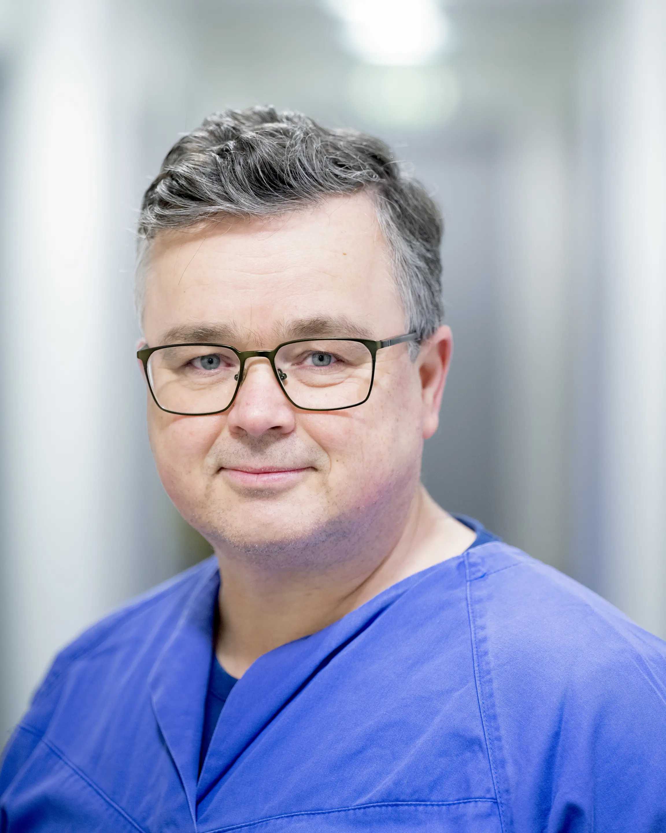 Mann med briller i blå skjorte