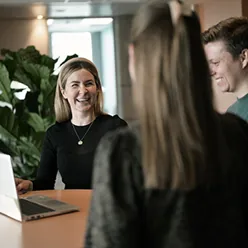 A group of people looking at a laptop
