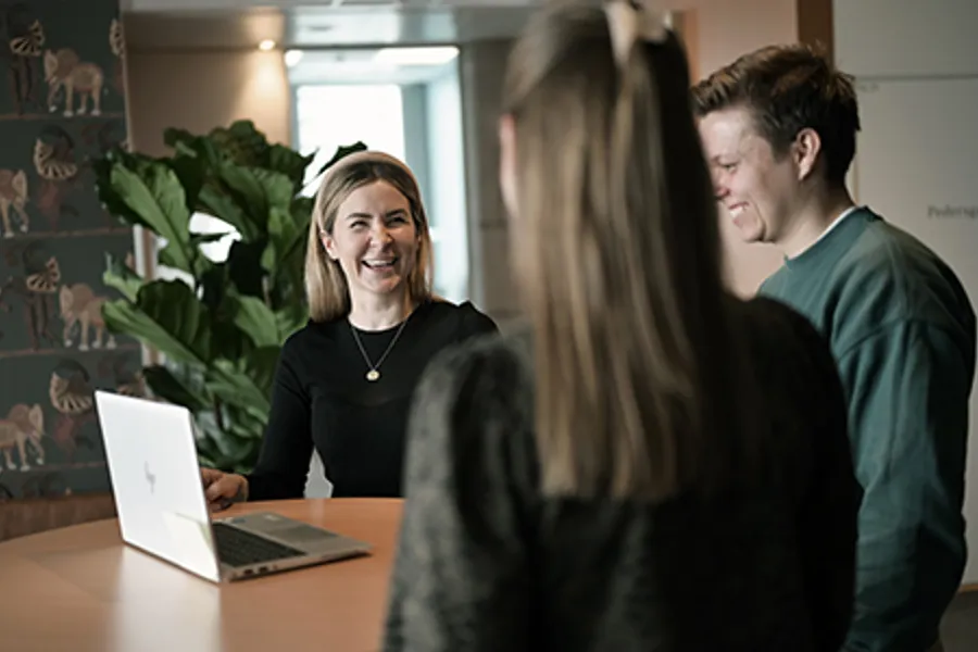 A group of people looking at a laptop