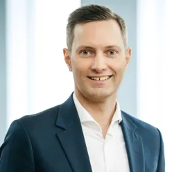 En mann i dress som smiler