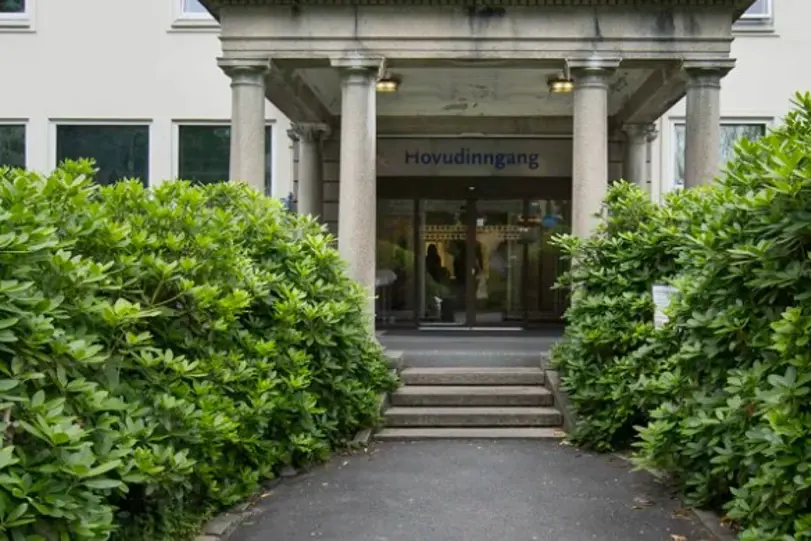 En bygning med gangvei og planter foran den