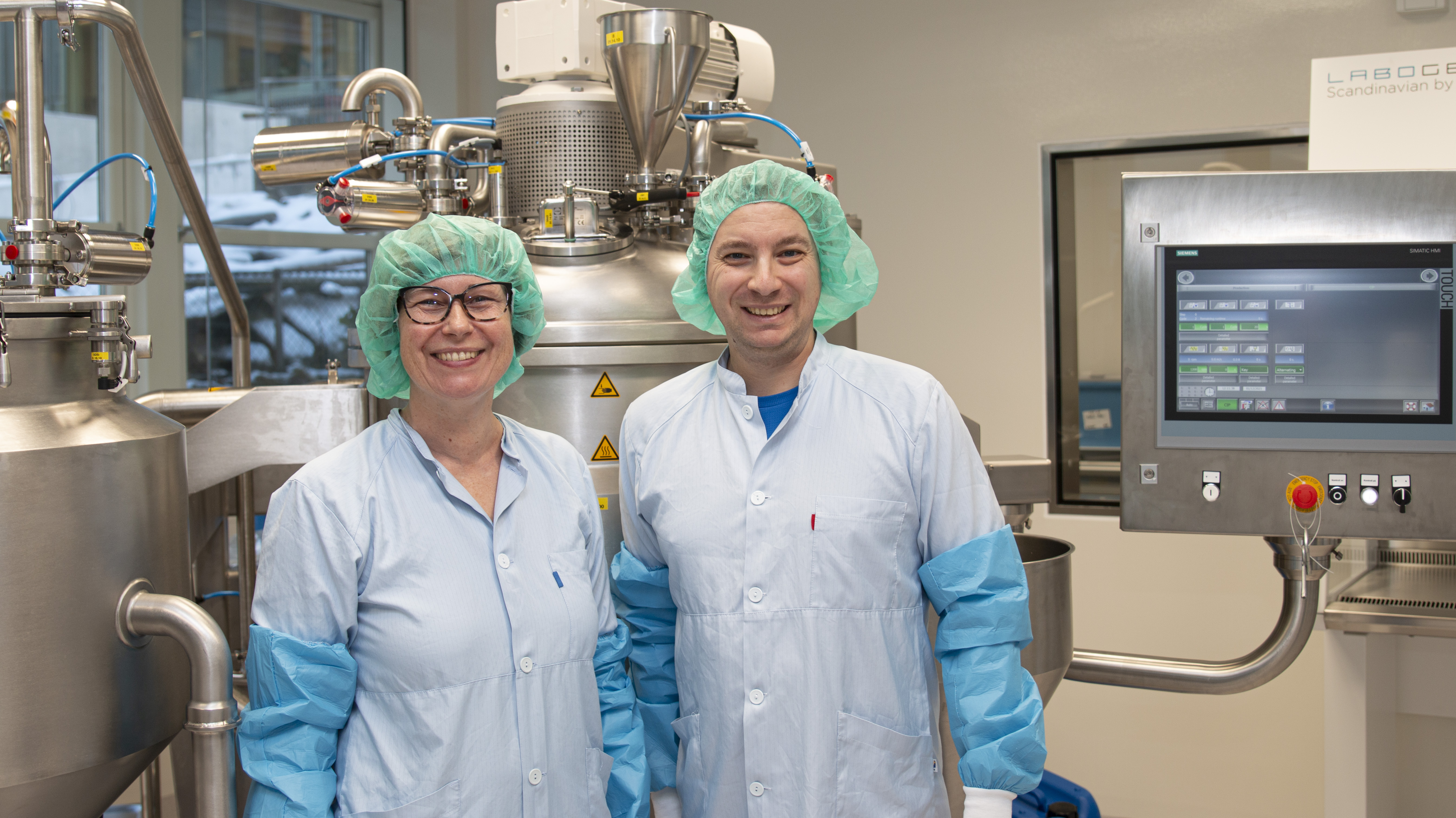 Et par personer iført kirurgiske skrubber og masker