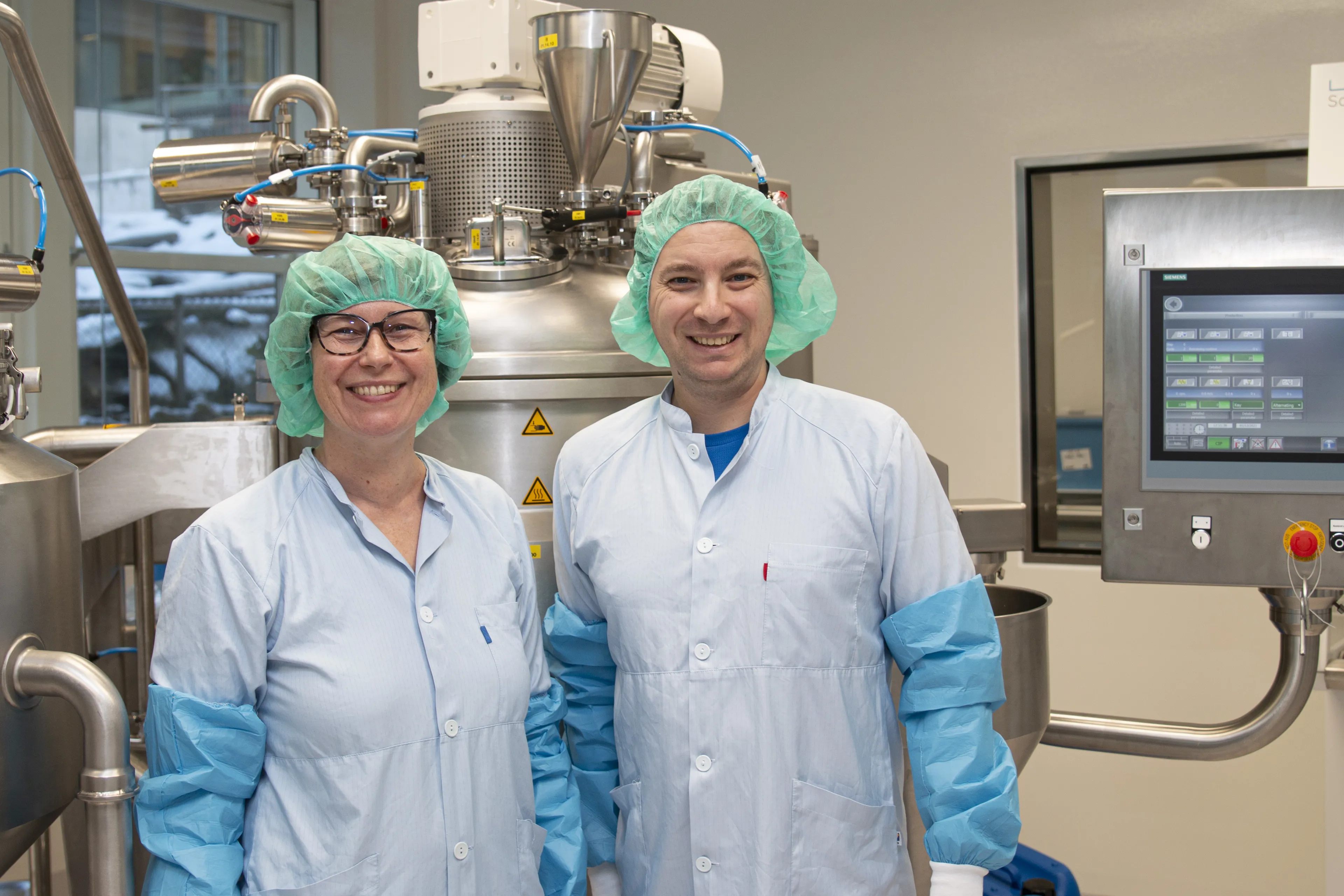 A couple of people wearing surgical scrubs and masks