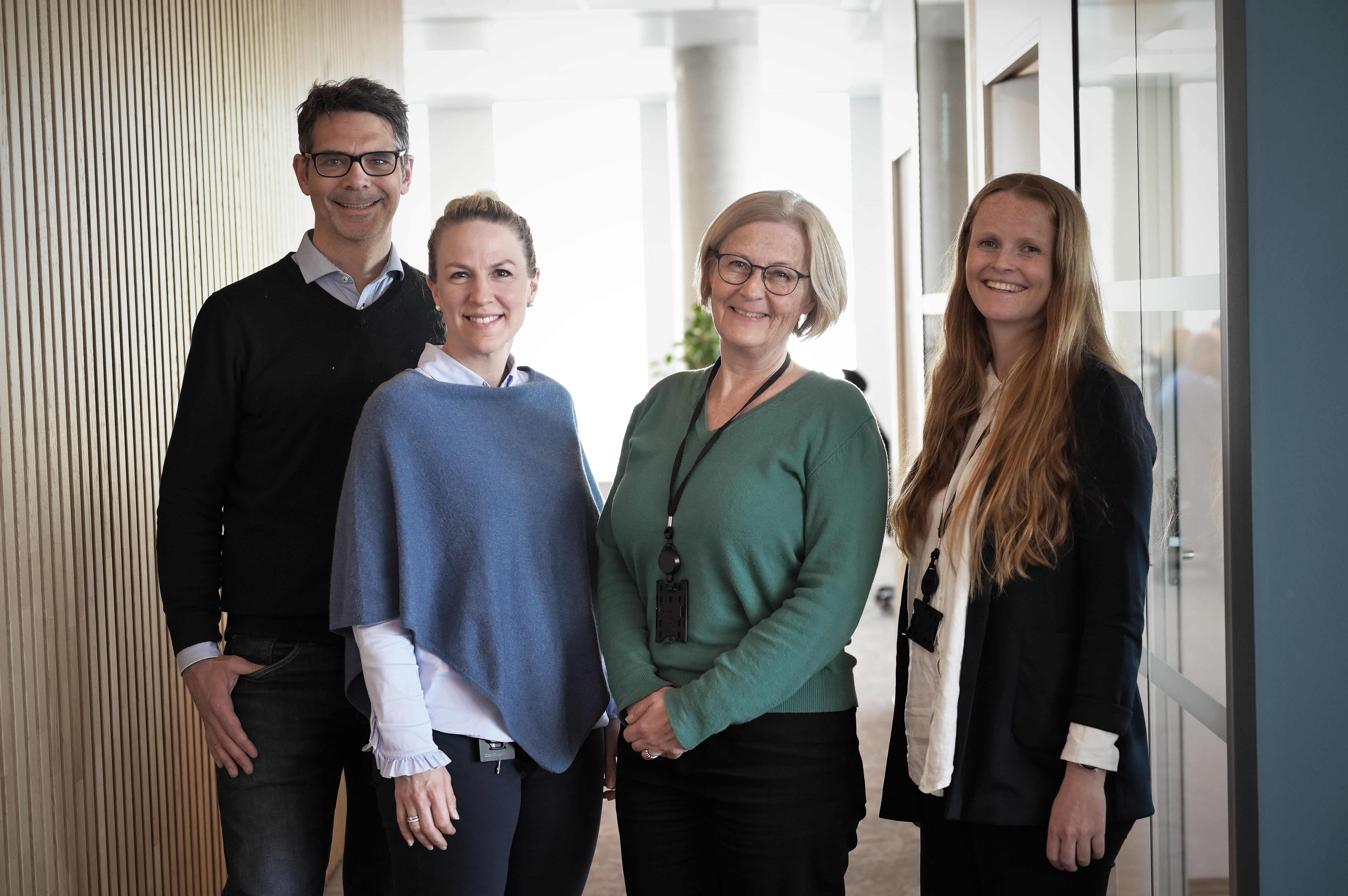 tre damer og en mann som smiler