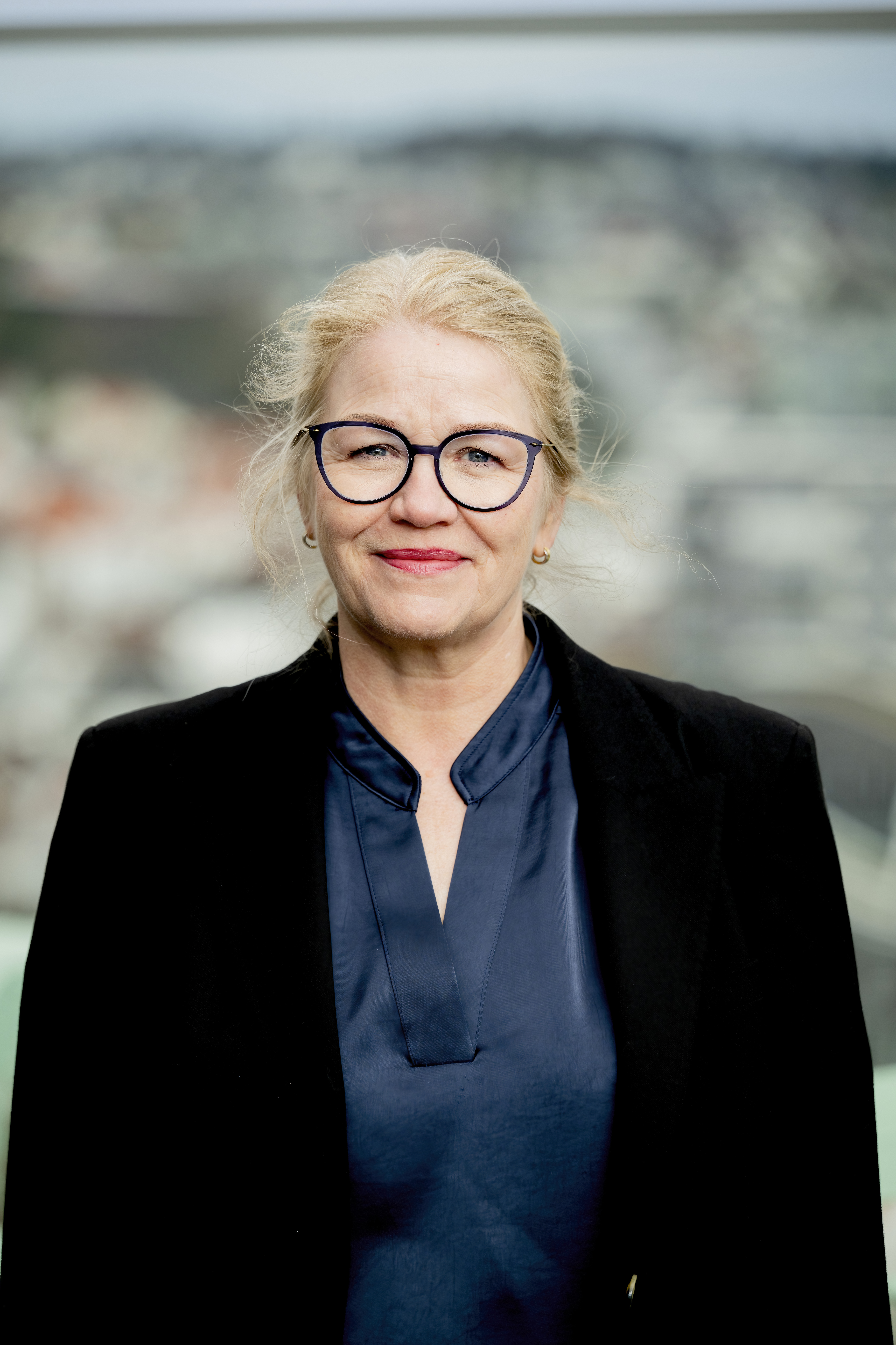 Dame med briller ser mot kamera