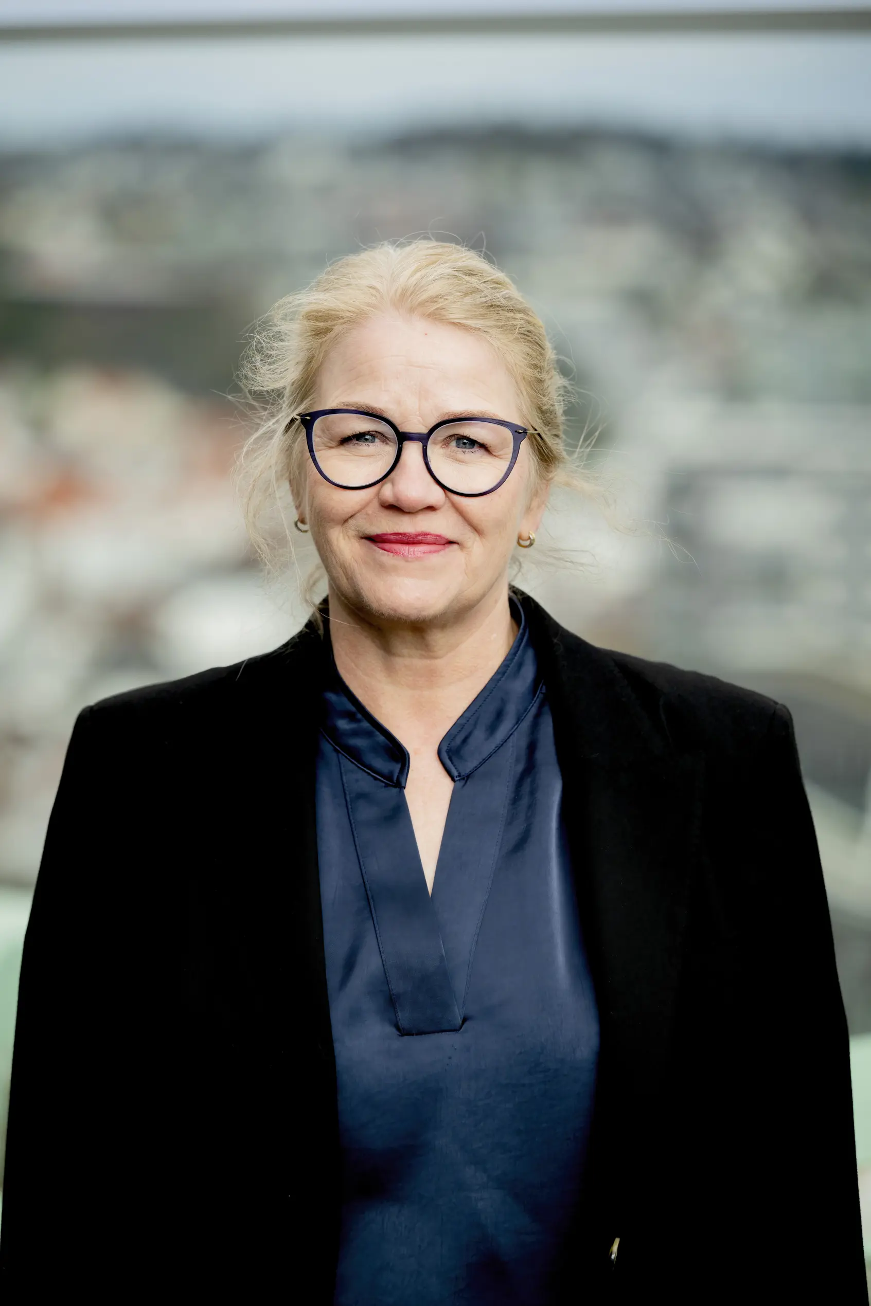 Dame med briller ser mot kamera