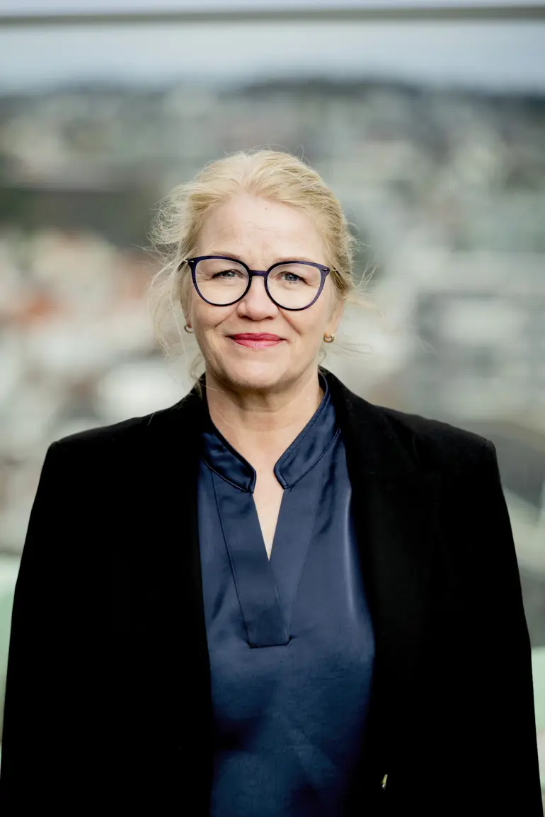 Dame med briller ser mot kamera