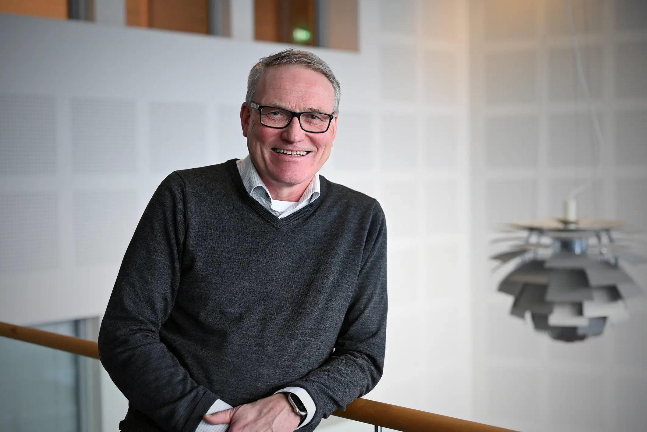 mann med briller lener seg på toppen av trapp