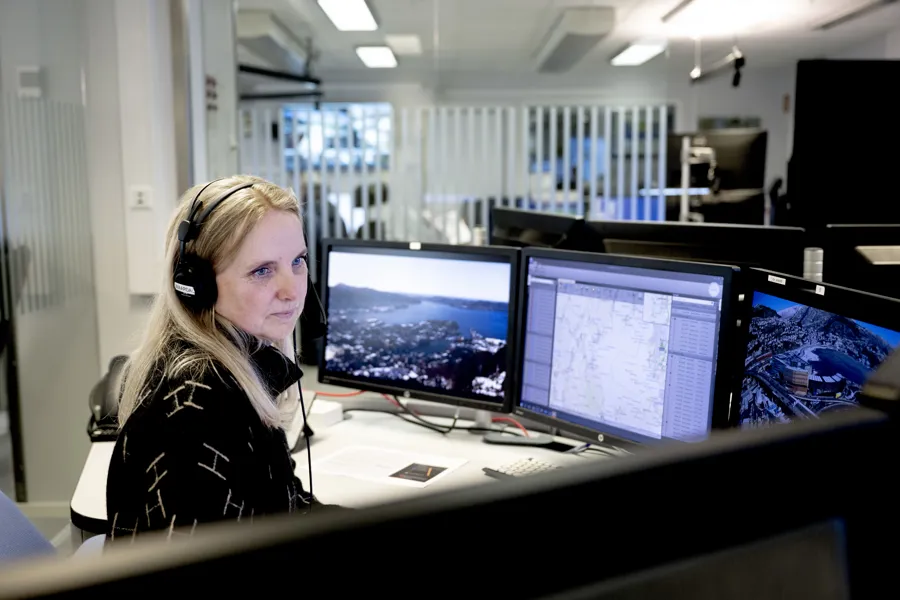 Dame med headset foran PC-skjerm