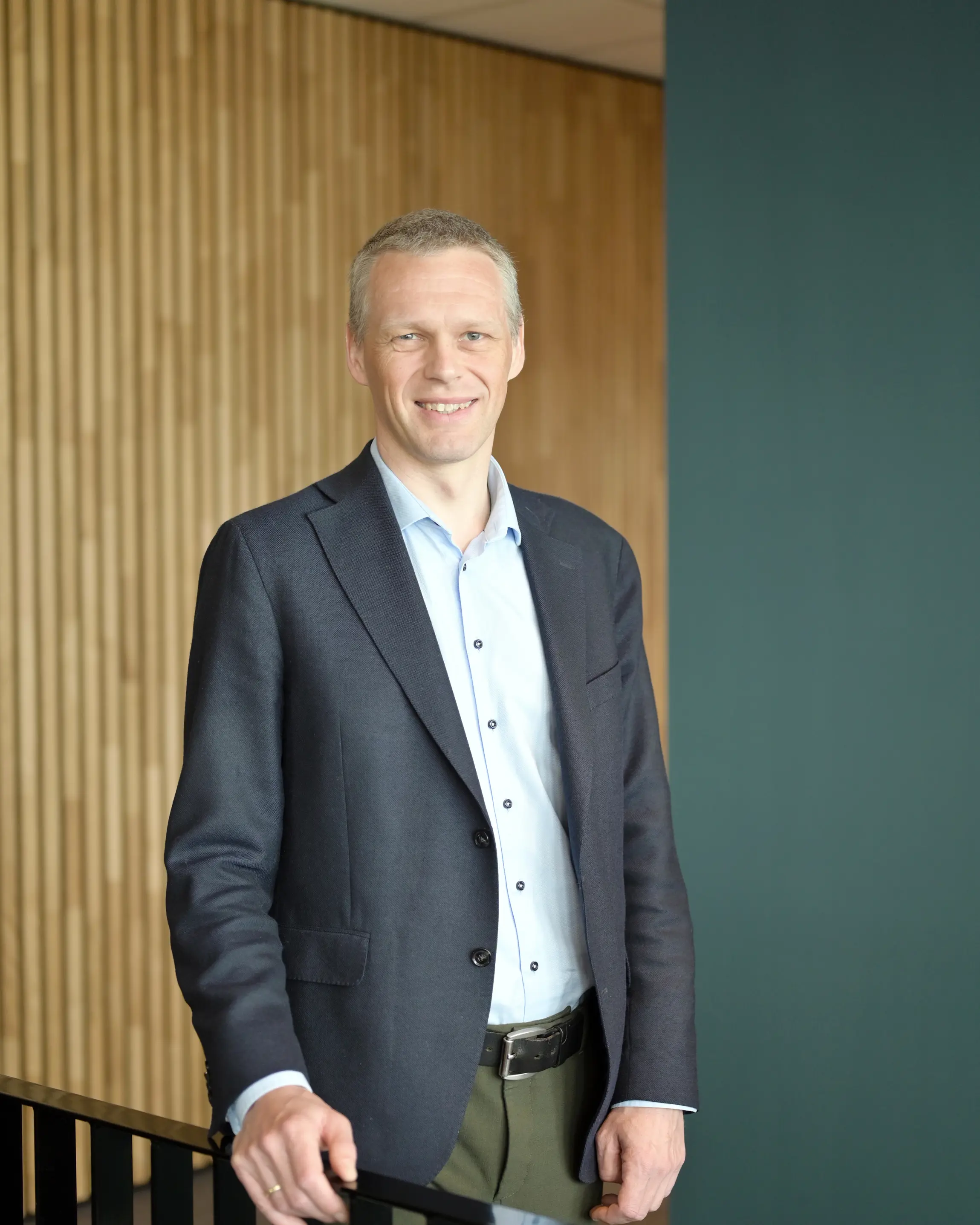 Mann står og smiler