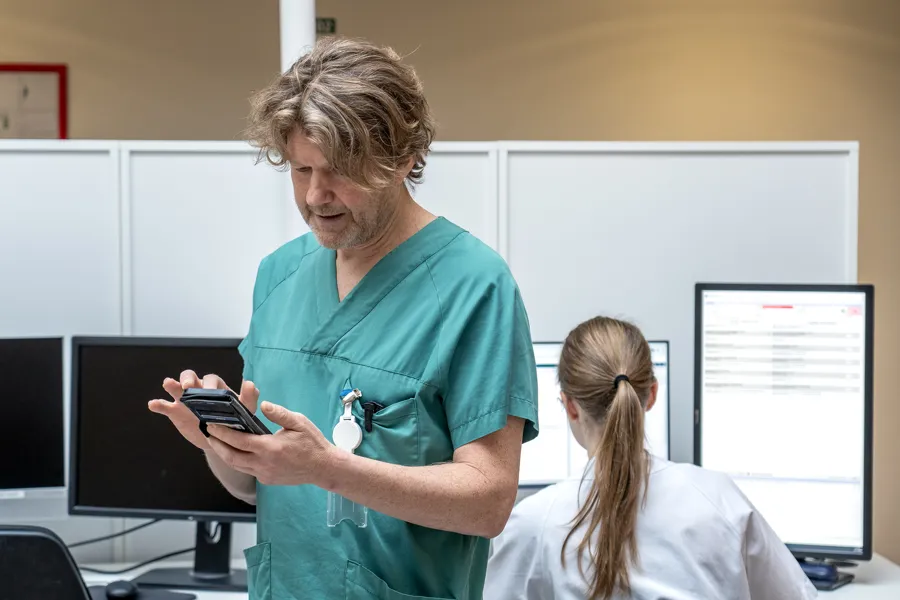 En kvinne som viser en mann noe på nettbrettet