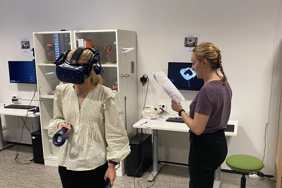 A couple of women wearing vr goggles and holding a piece of paper