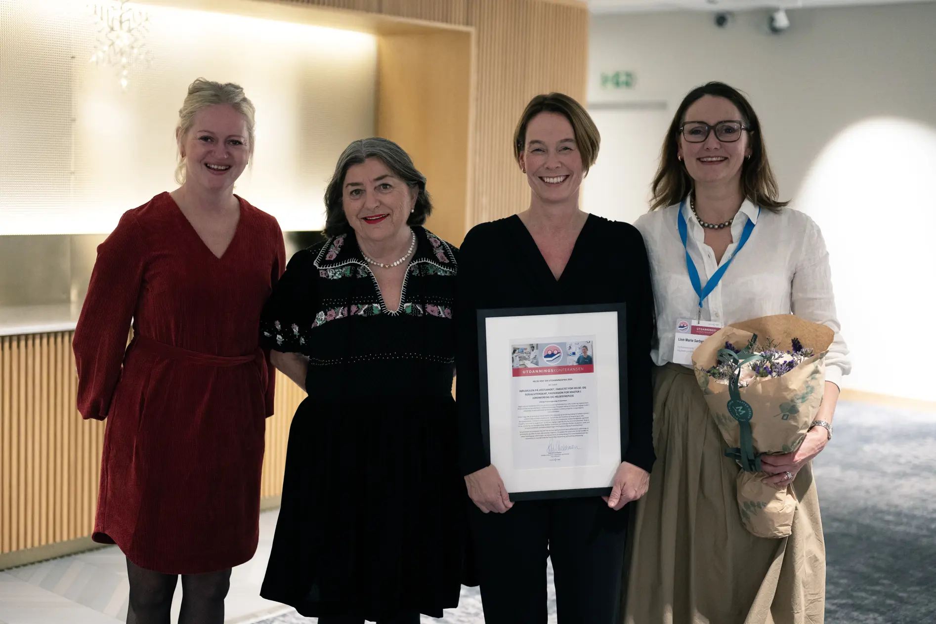 Fire personer med diplom og blomster