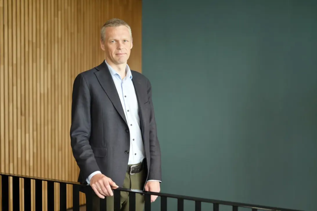 En mann som står foran en grønn skjerm