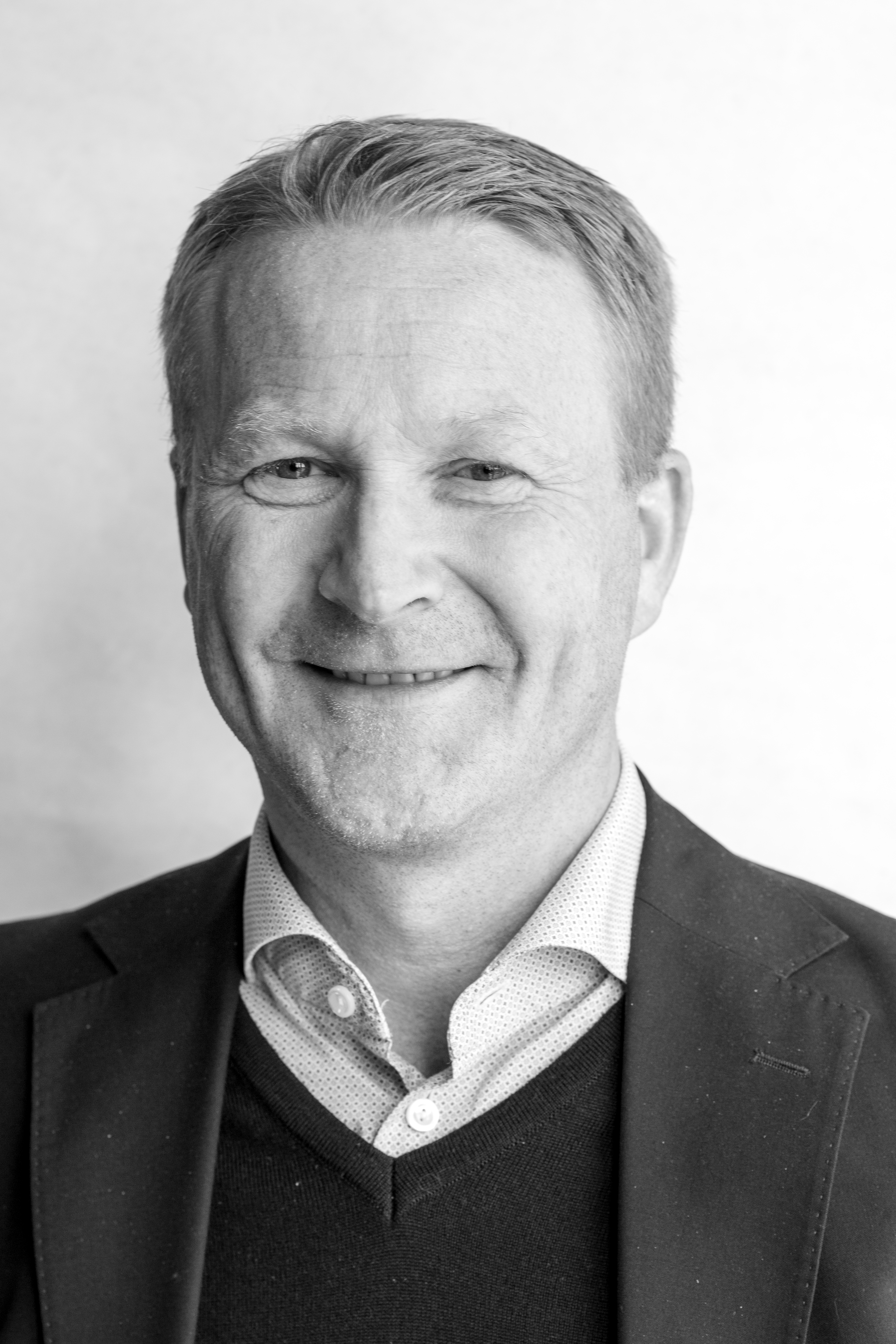 Mann smiler mot kameraet. Foto.